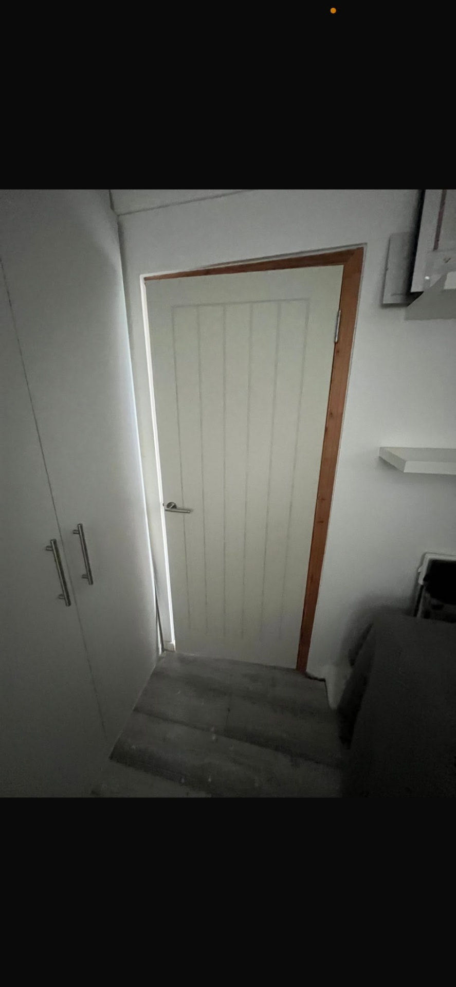 Newly hung white door at the top of the staircase