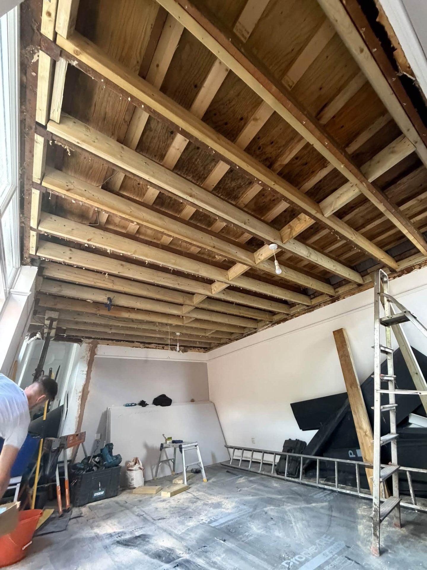 New ceiling joists installed across the room during the rebuild