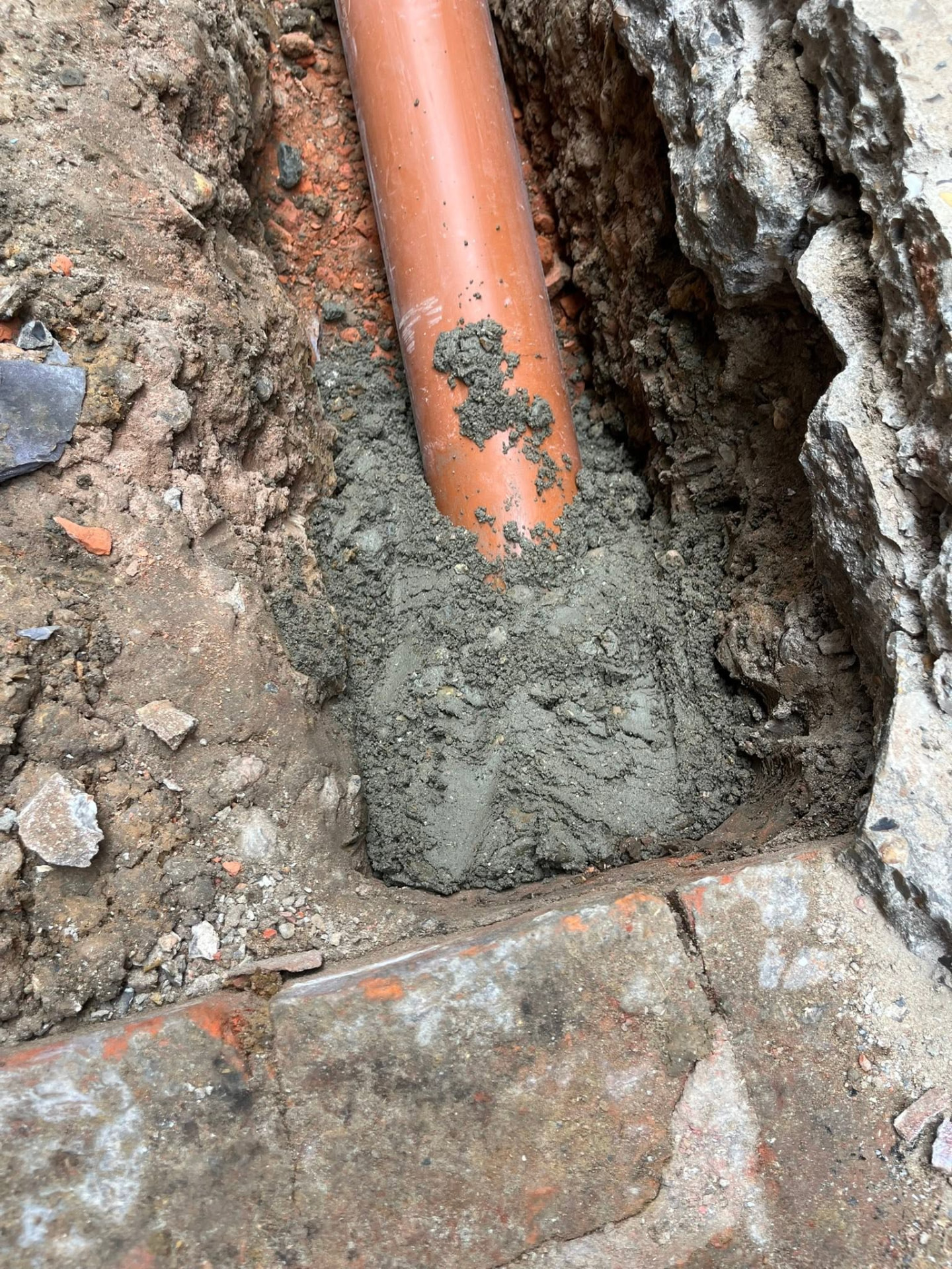 New pipe connection into the chamber sealed and haunched with fresh mortar
