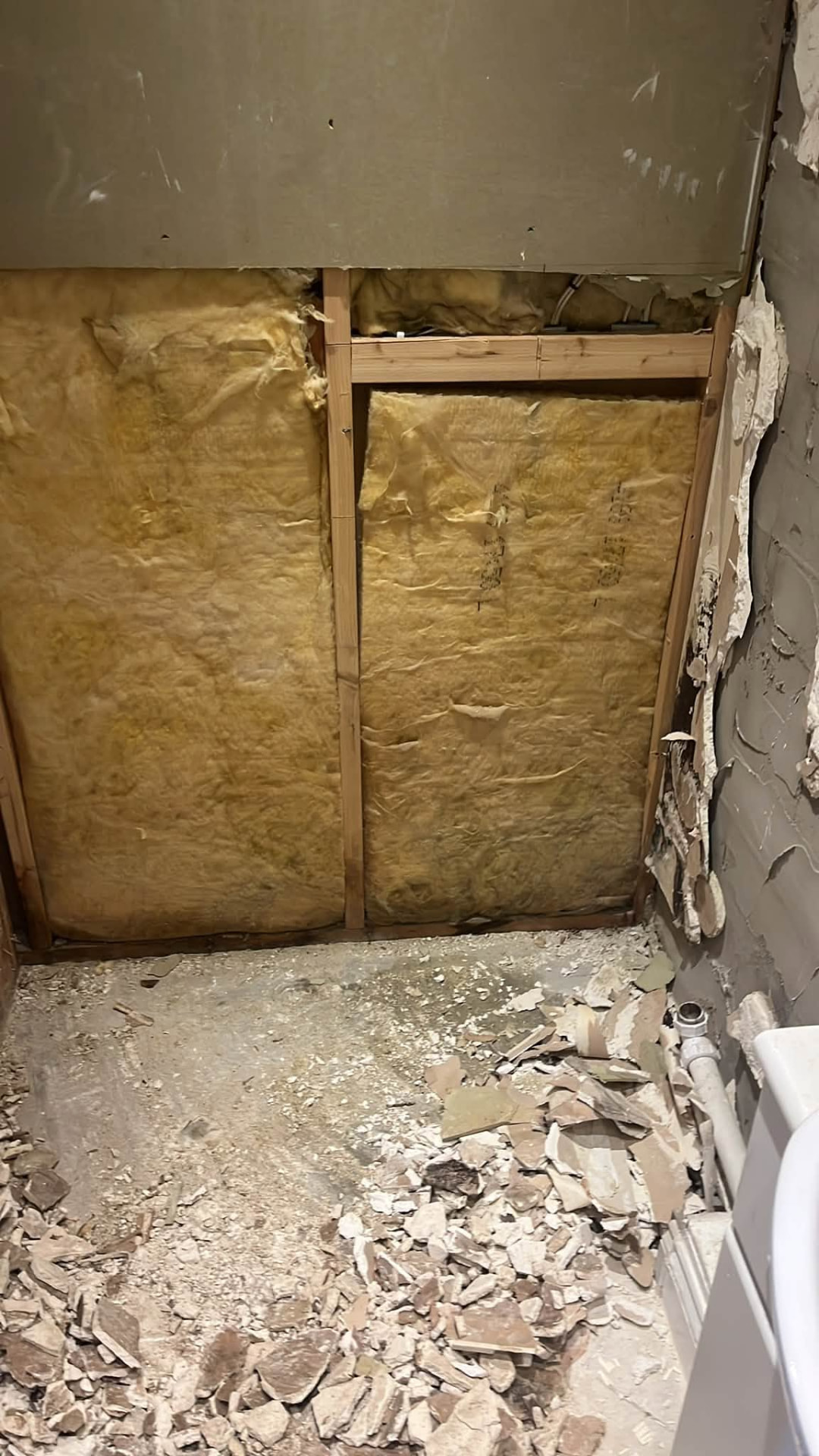 Insulated stud wall prepared for new boarding in the shower recess