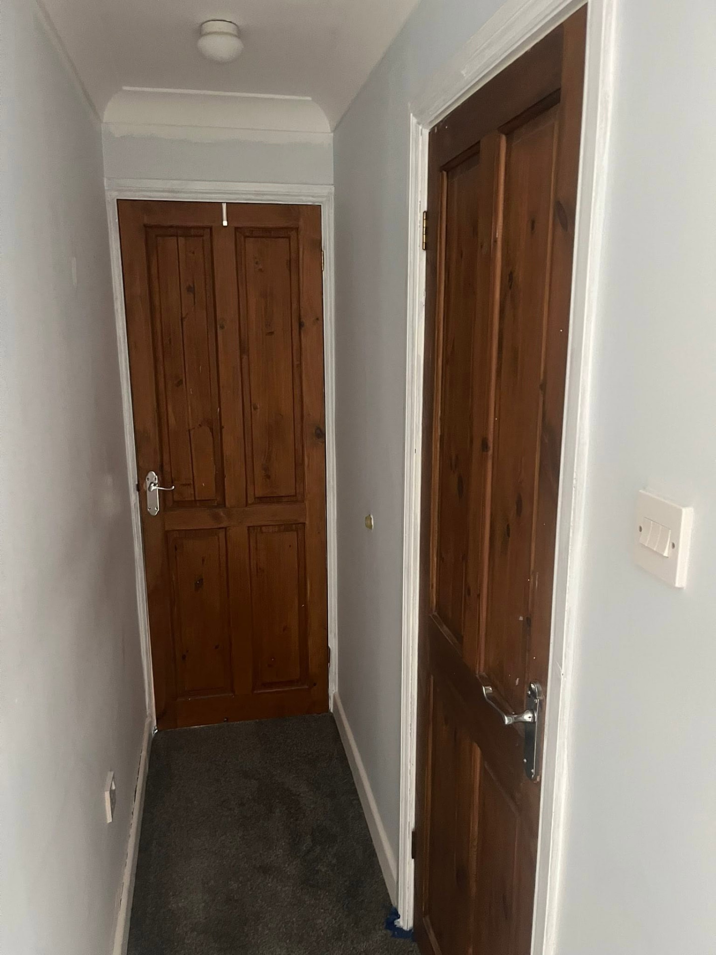 Landing with old varnished pine doors before replacement
