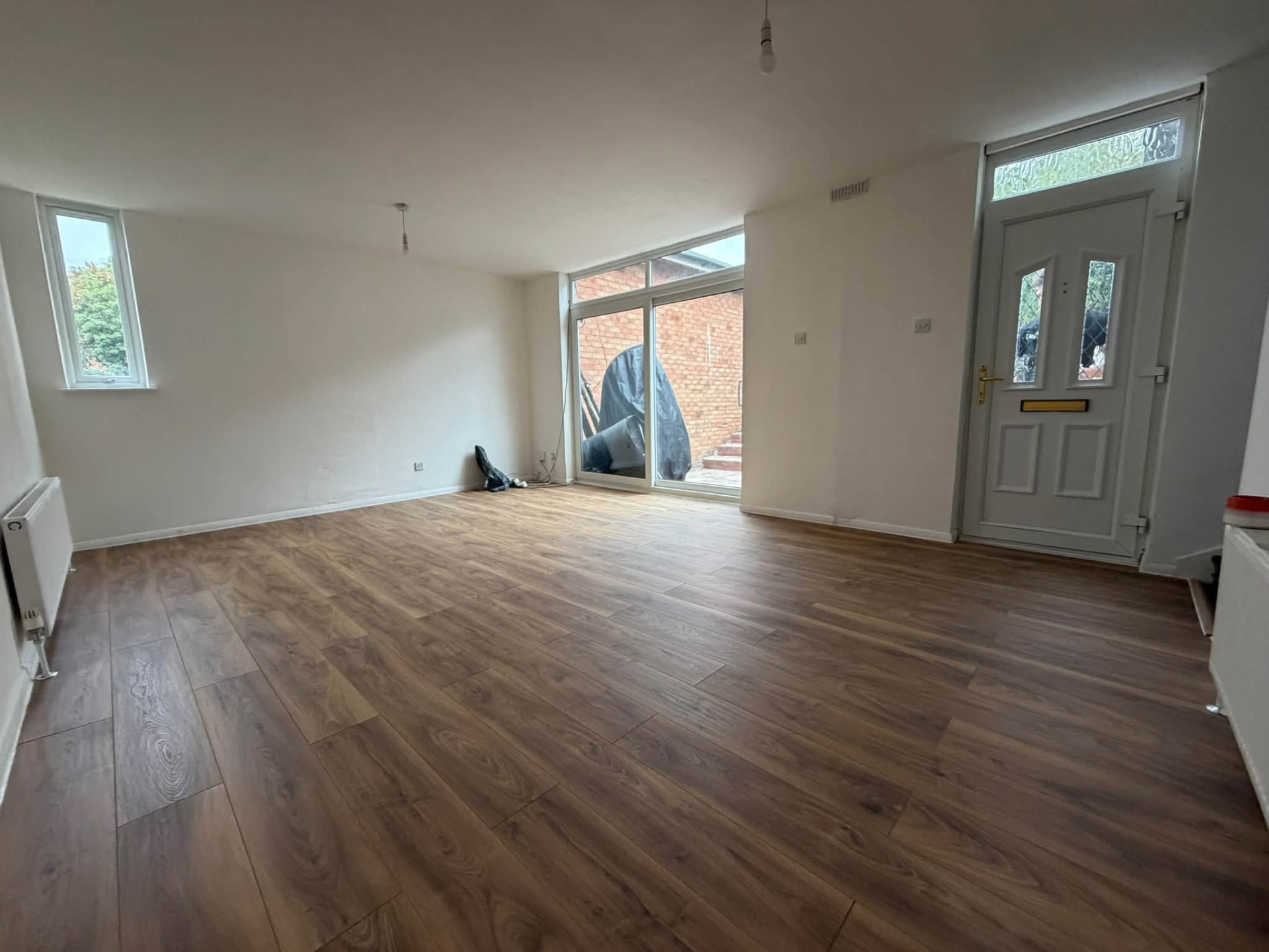 Completed living room with new flooring, painted walls and modern patio doors