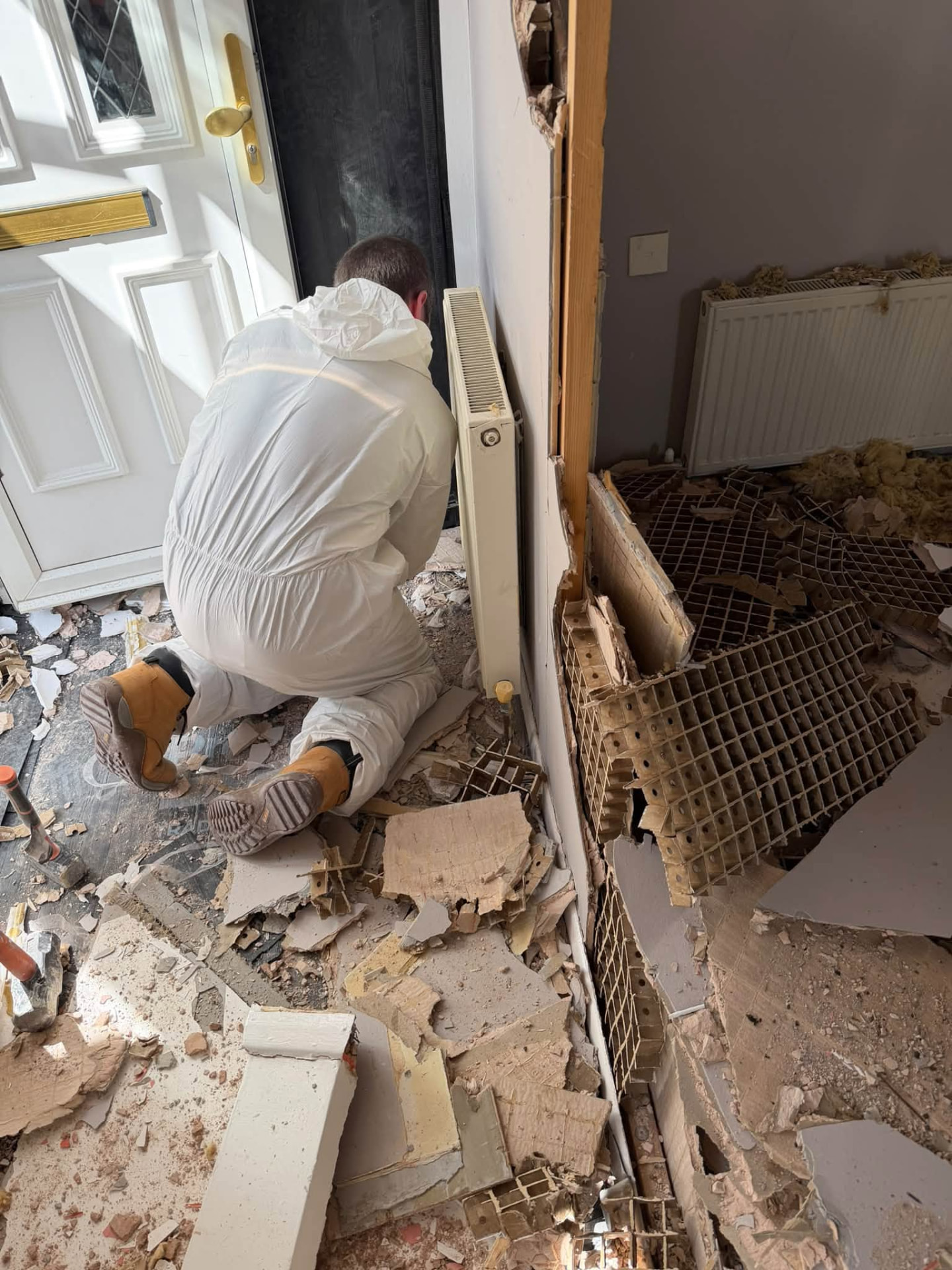 Trade Rescue 24/7 team removing damaged materials by the front entrance