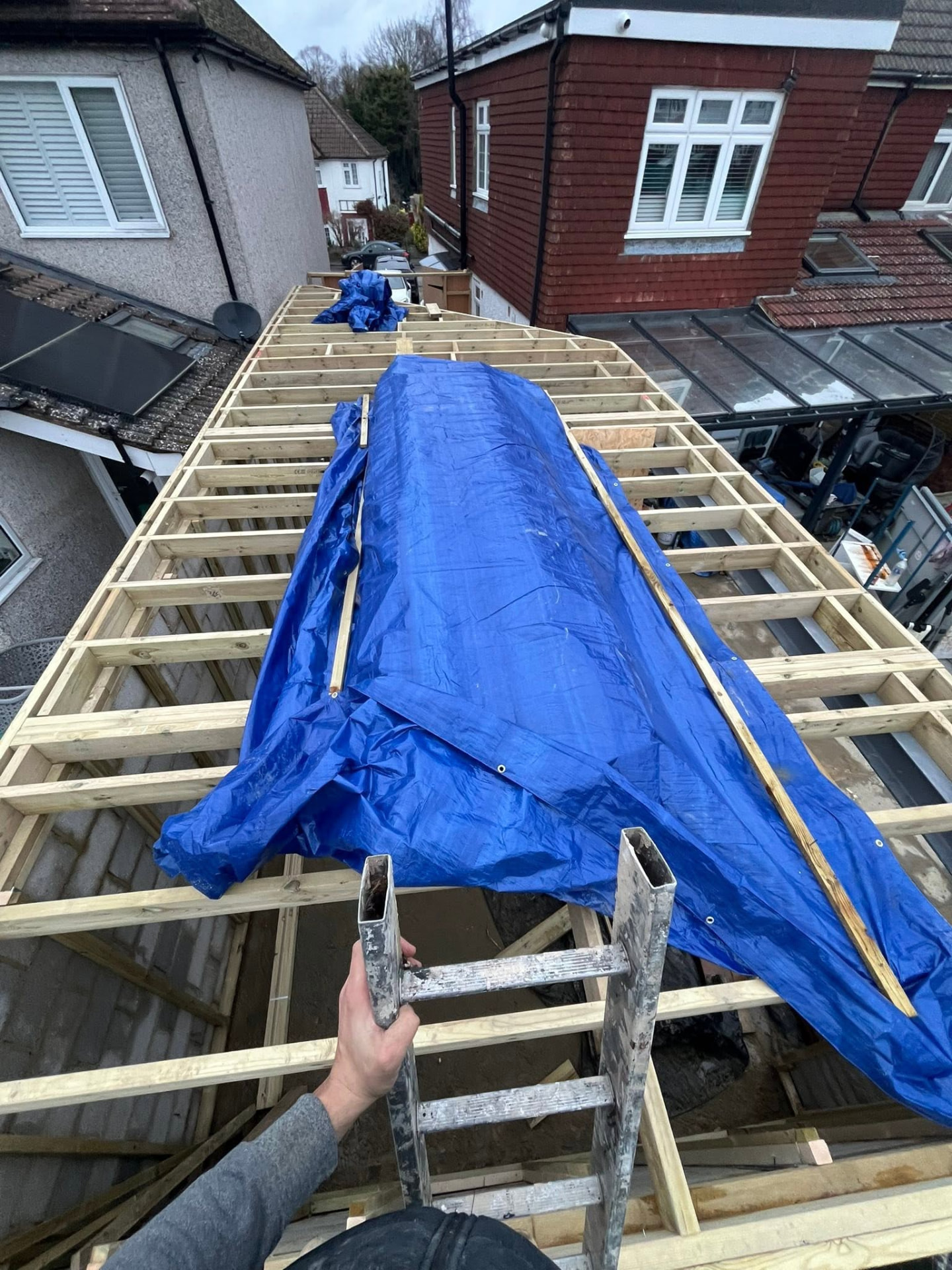 Roof joists sheeted over and protected with tarpaulin during works