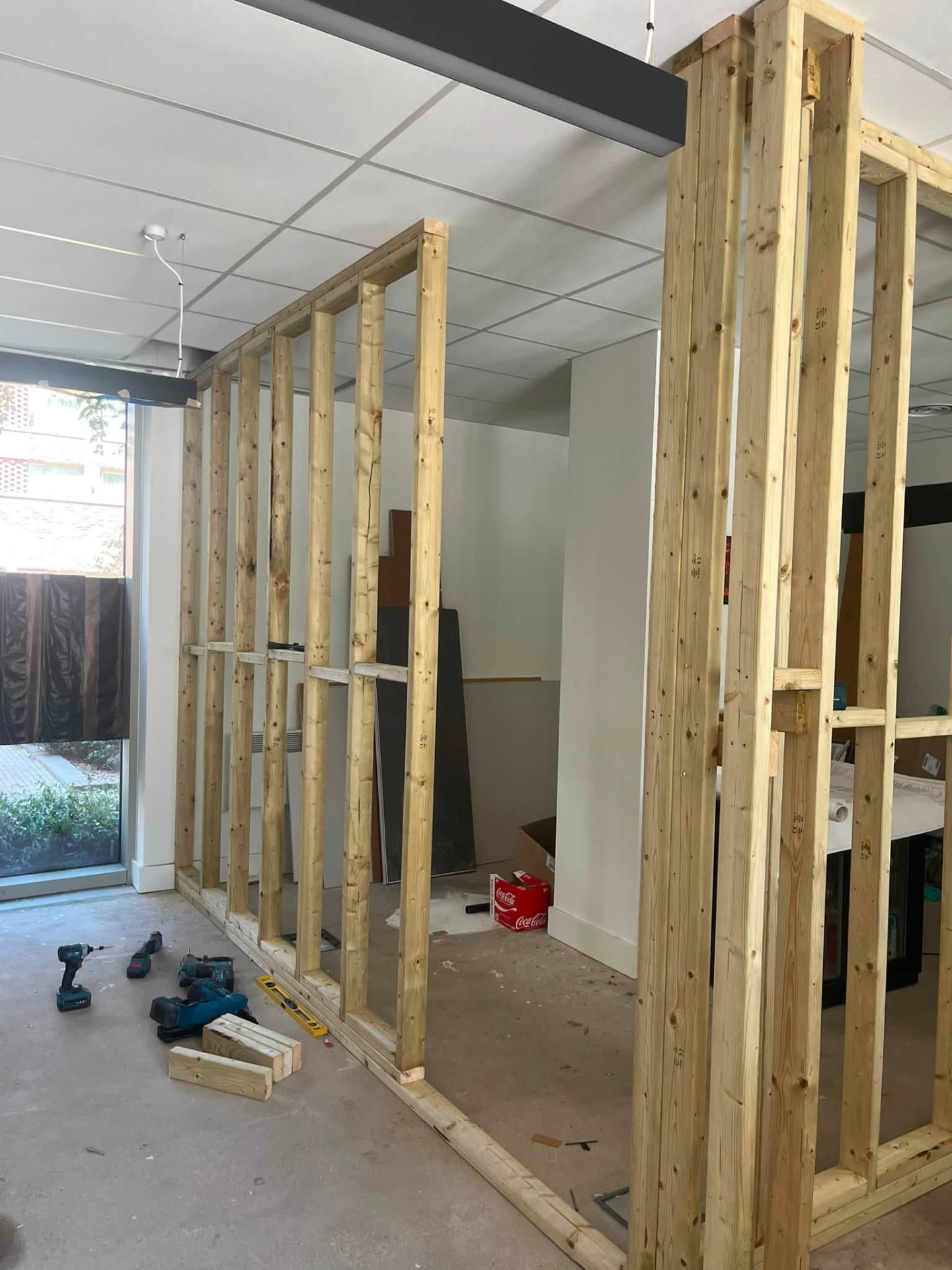 Multiple timber partition frames lined up across the commercial space