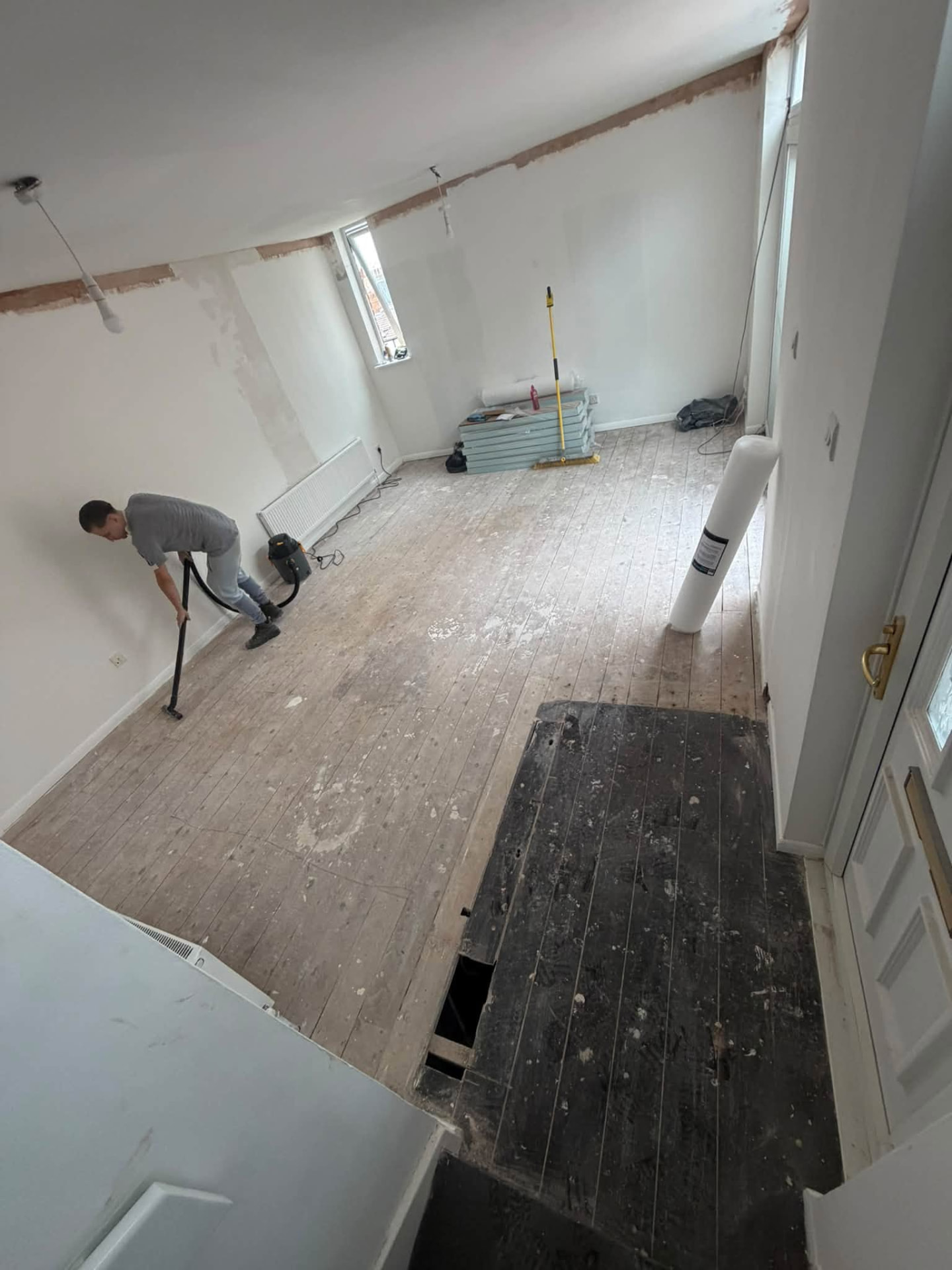 Room being prepared for final flooring with old boards lifted and floor cleaned