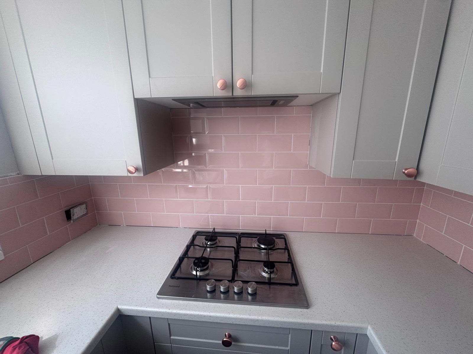 Full kitchen splashback and hob area with blush pink subway tiles and grey units
