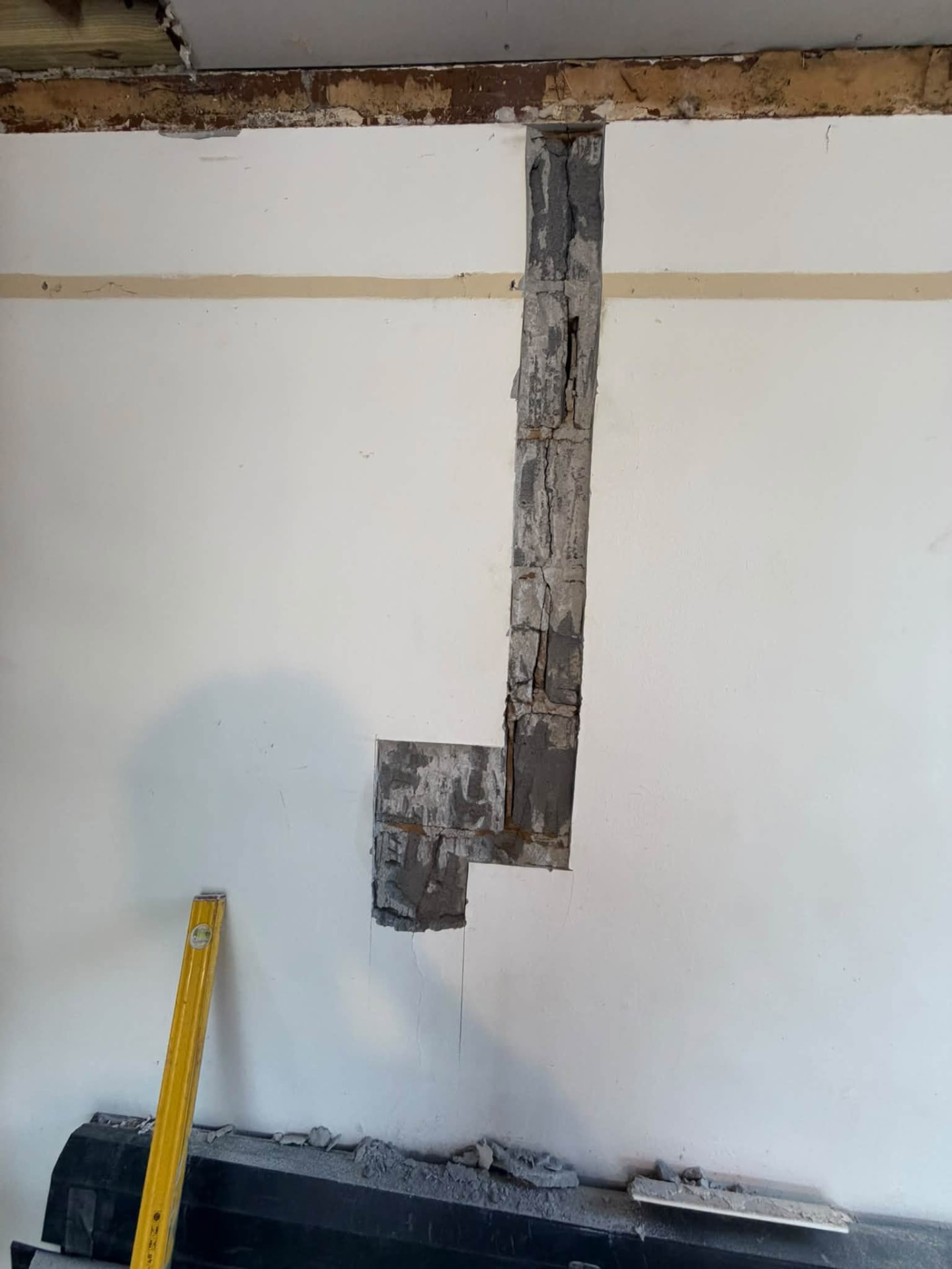 Wall chased out to expose blockwork and lintel area for repair