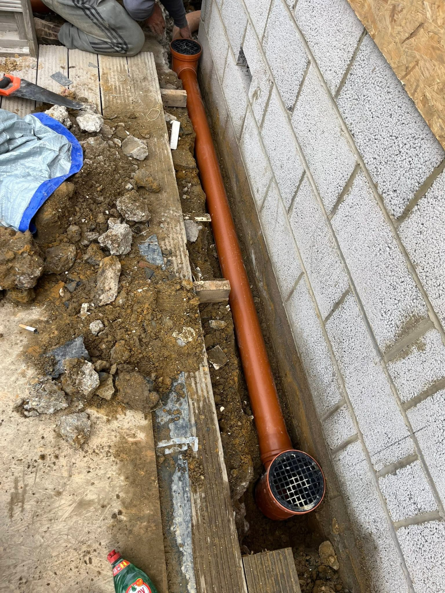 Completed 4-inch underground pipe run with two gullies installed along the wall