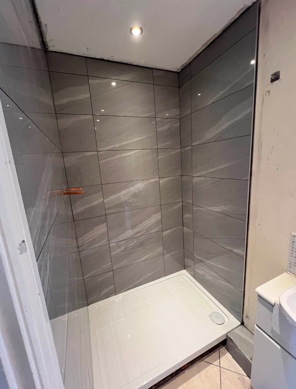 Finished shower with grey porcelain tiles, smoke grout and new shower tray