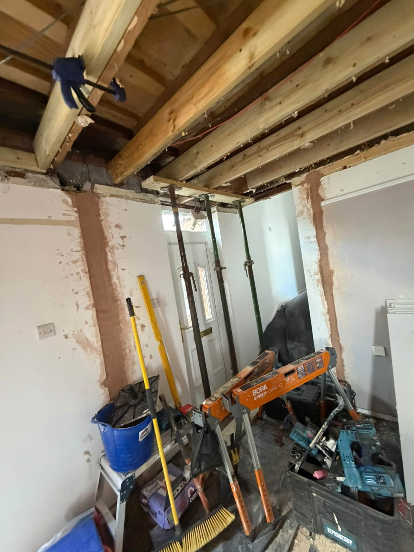 New timber beams in place with props supporting the opening