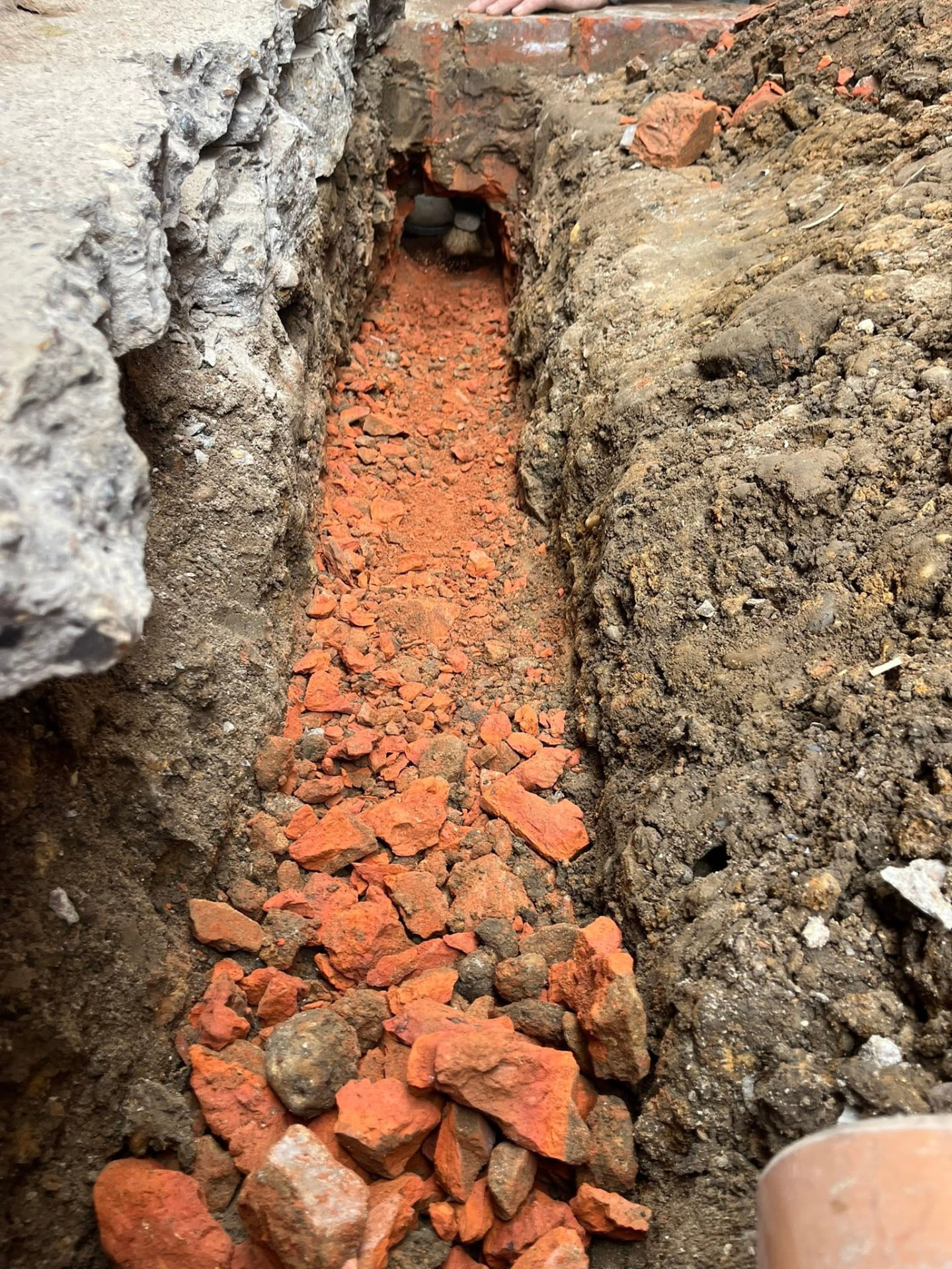 Trench bottomed out and prepared with bedding material for the new pipe