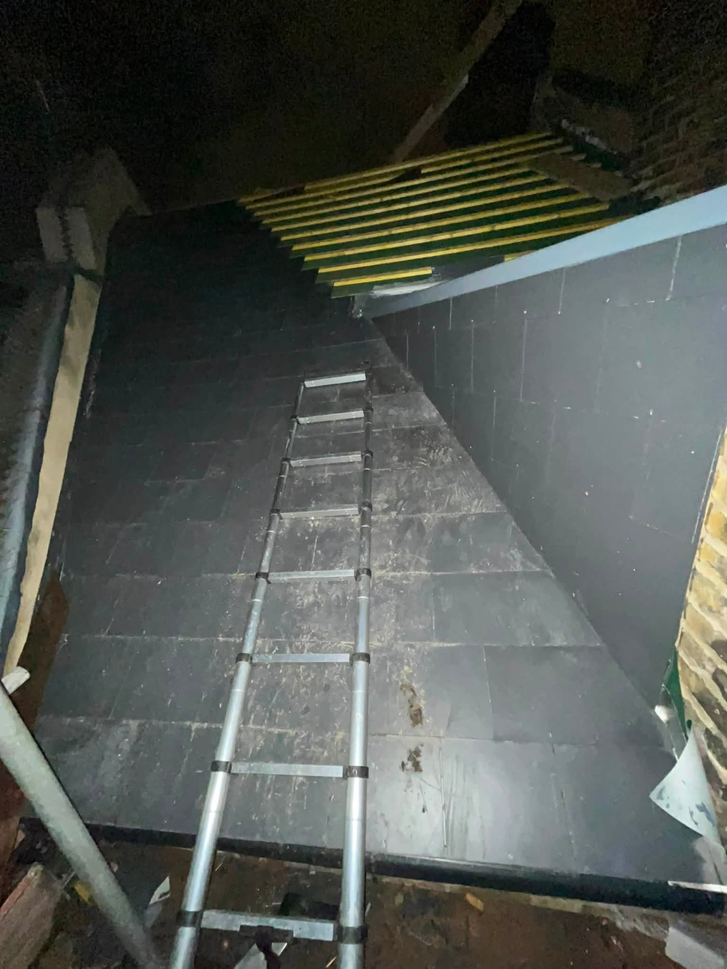 Evening progress shot of the slated roof and coated flat section