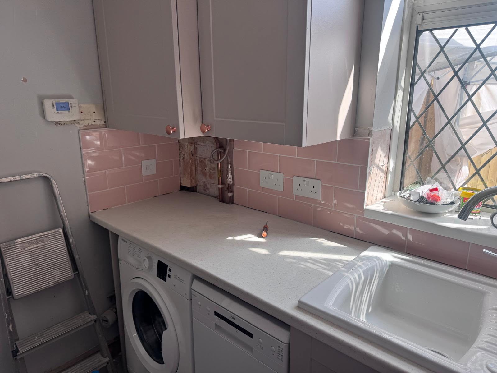 Completed pink tiled splashback along the appliance run