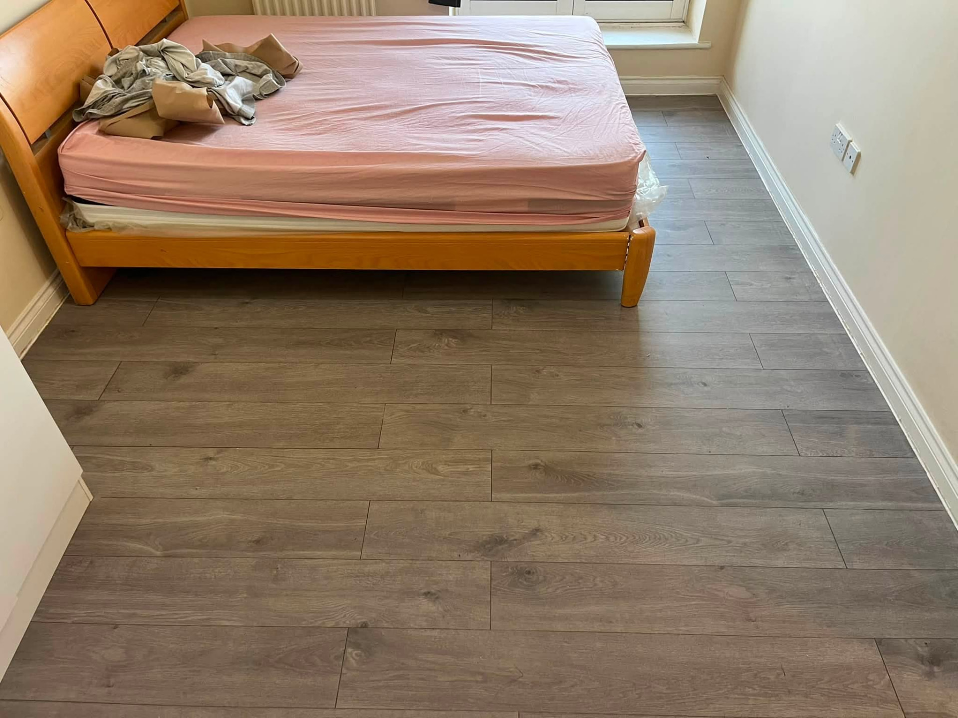 Finished bedroom flooring running neatly to the skirting and radiator