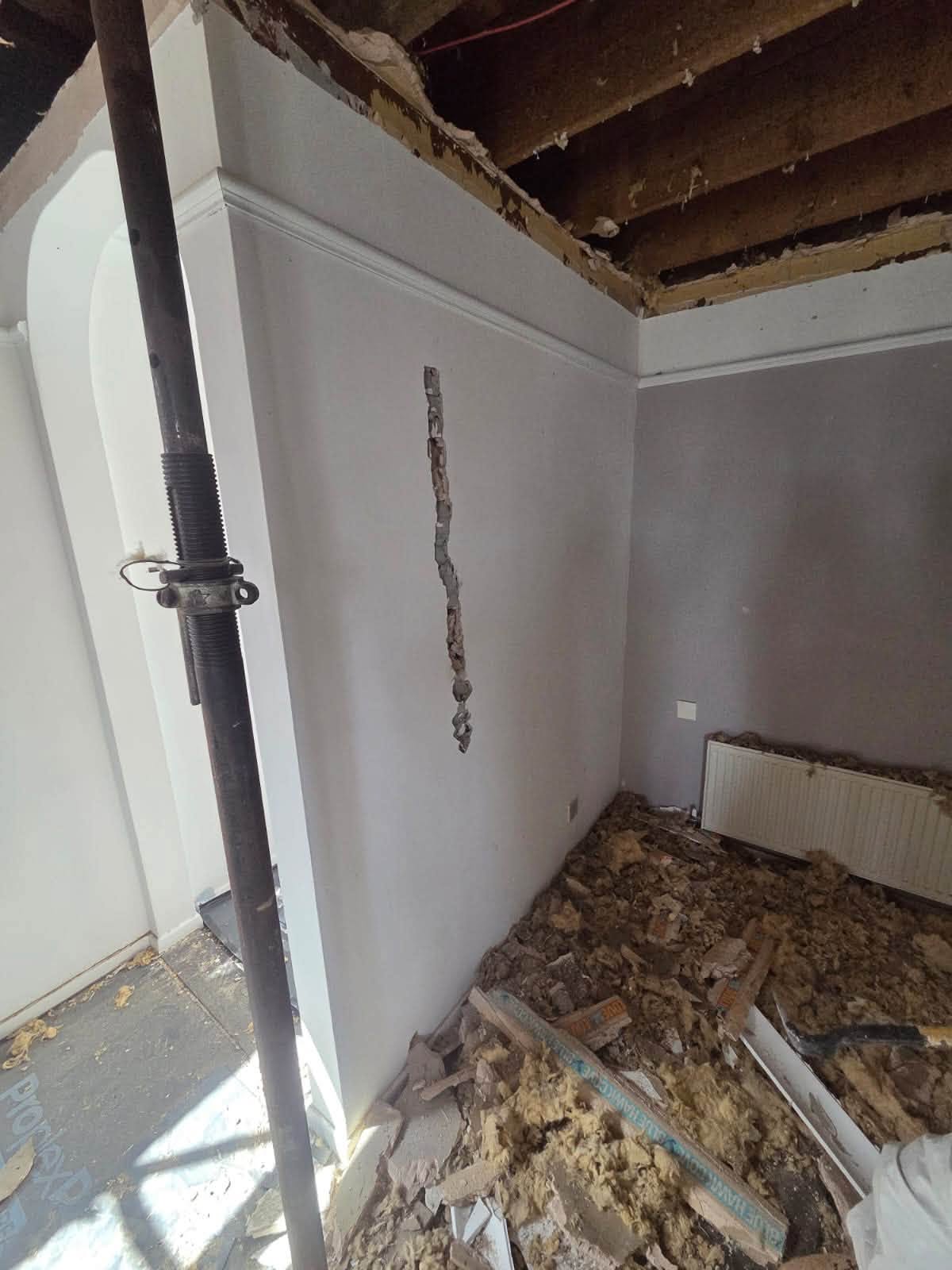 Corner of the room stripped back showing the extent of the structural damage