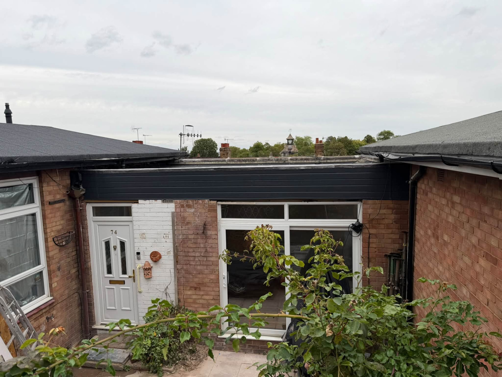 External rear view showing the completed roof, cladding and patio door installation