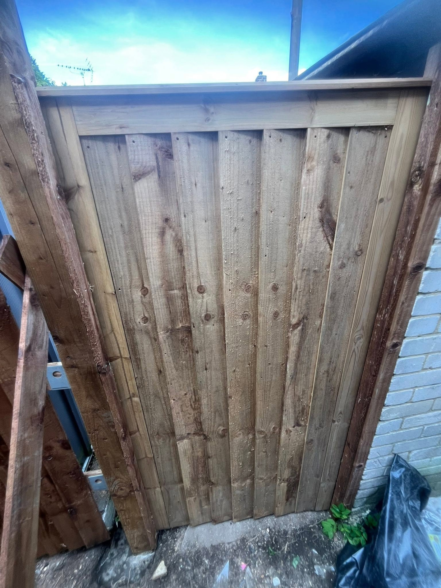 Newly built timber gate hung between the finished fence posts