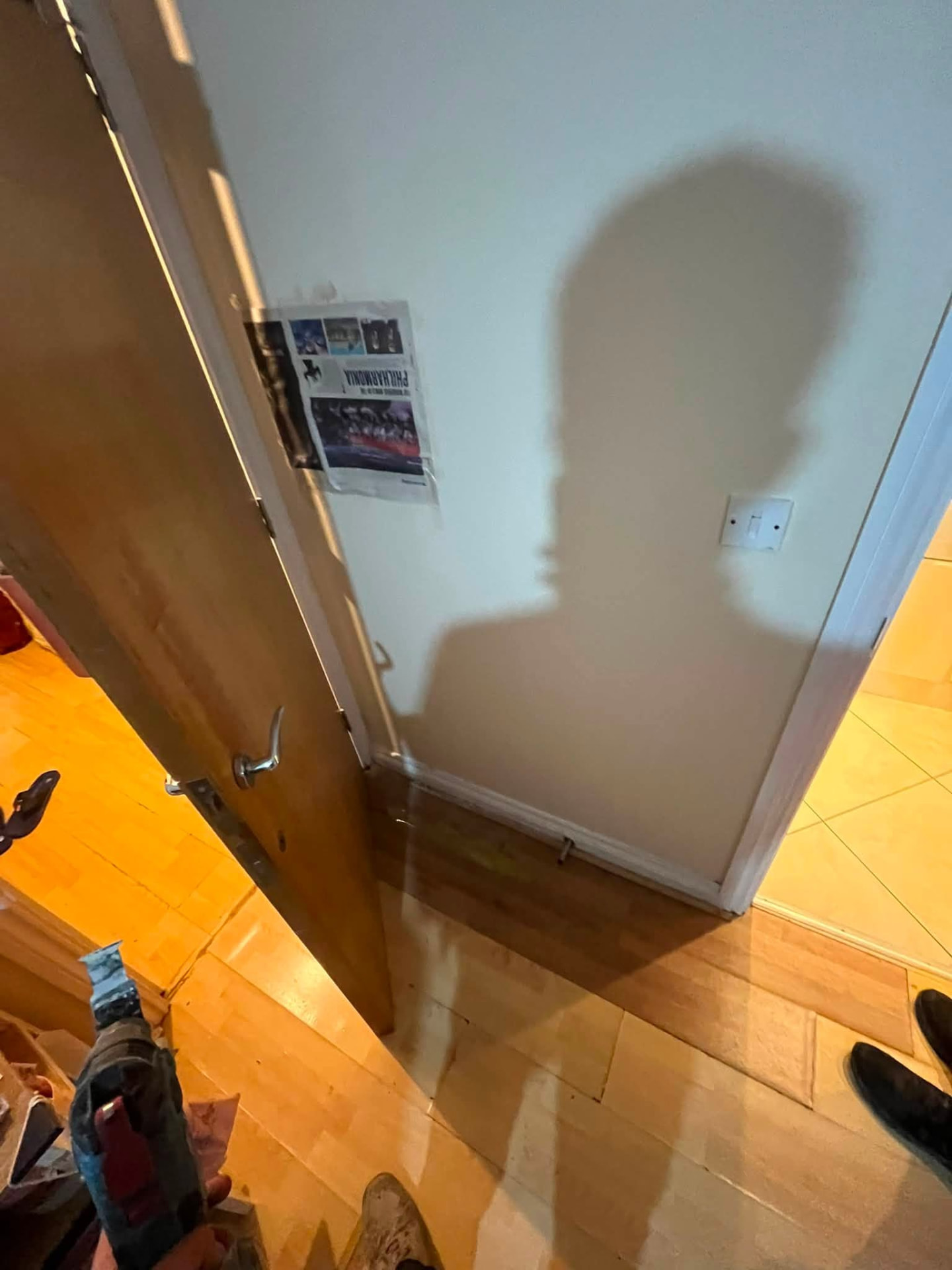 Hallway door and flooring showing signs of water damage from the hidden leak