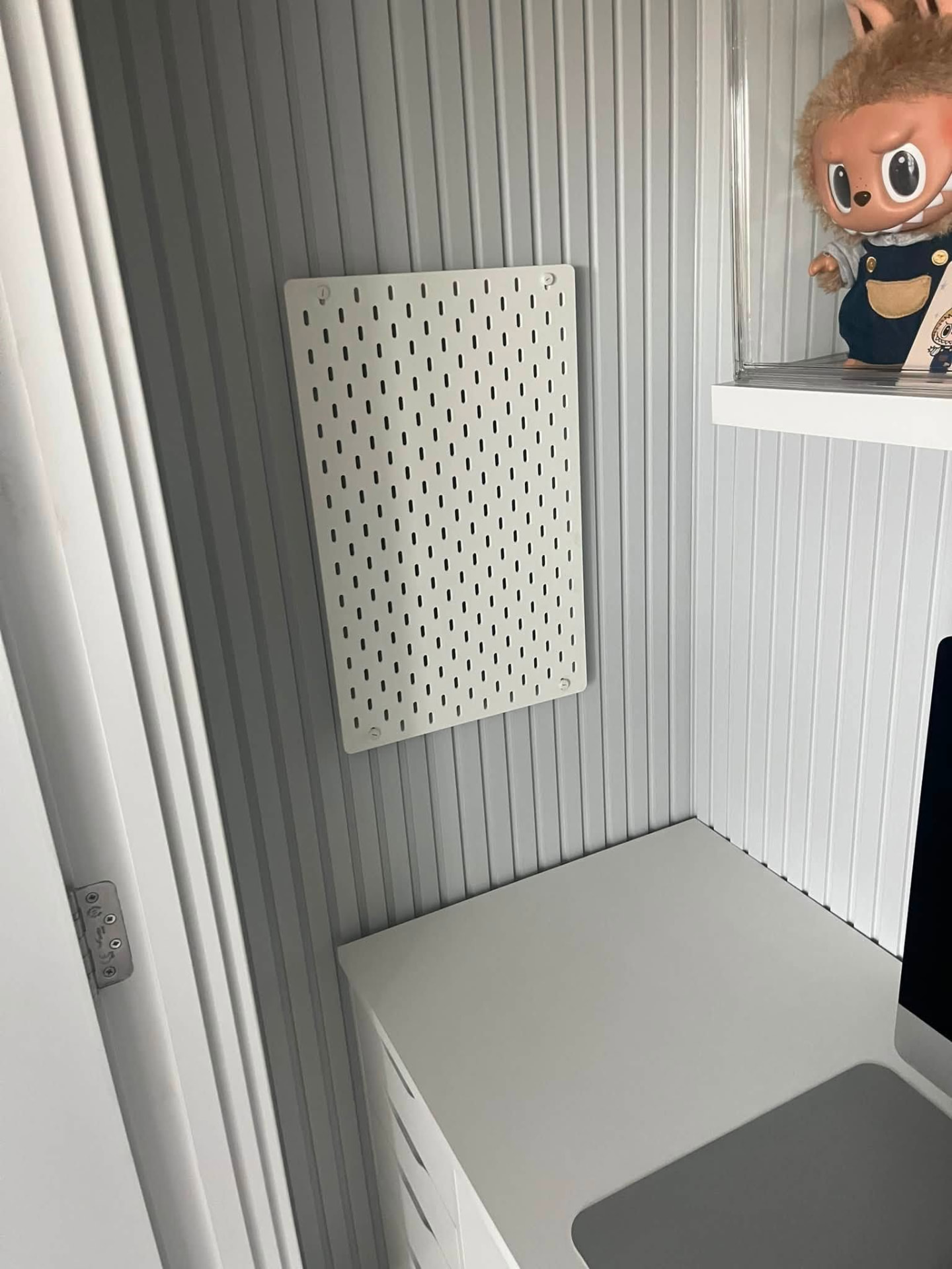 Neatly installed white IKEA pegboard fixed securely to the wall