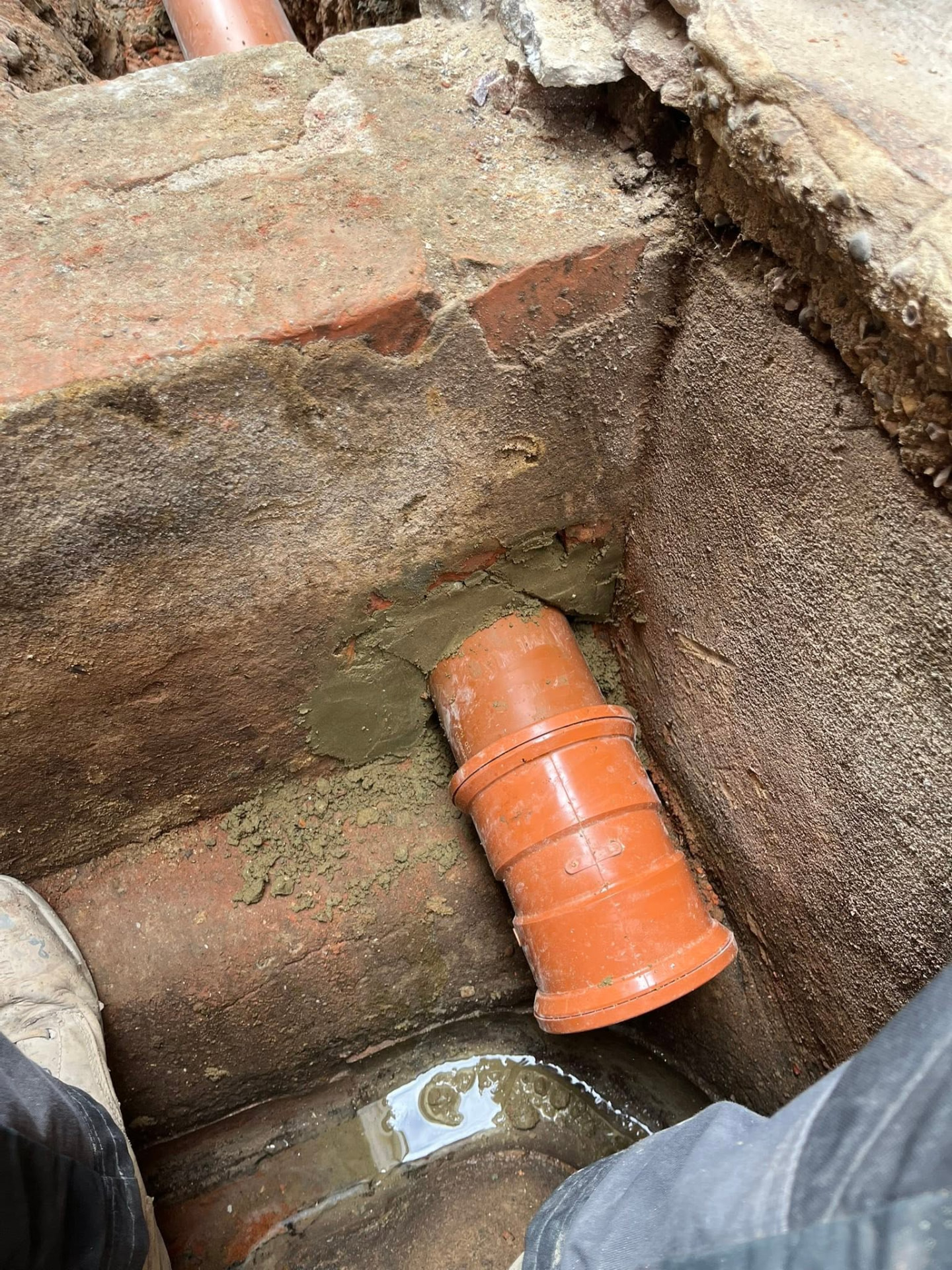 New pipe neatly connected and haunched into the existing brick chamber
