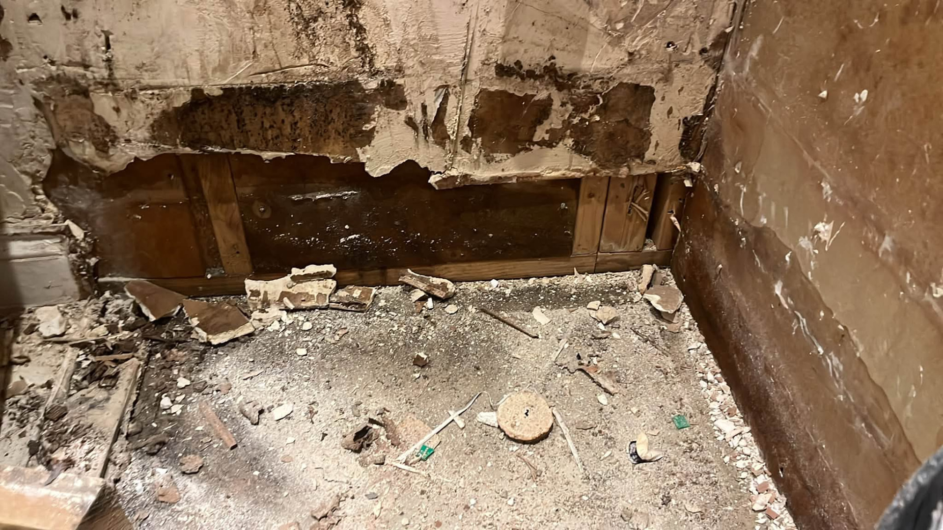Damaged wall base and timbers exposed where the leak had been tracking