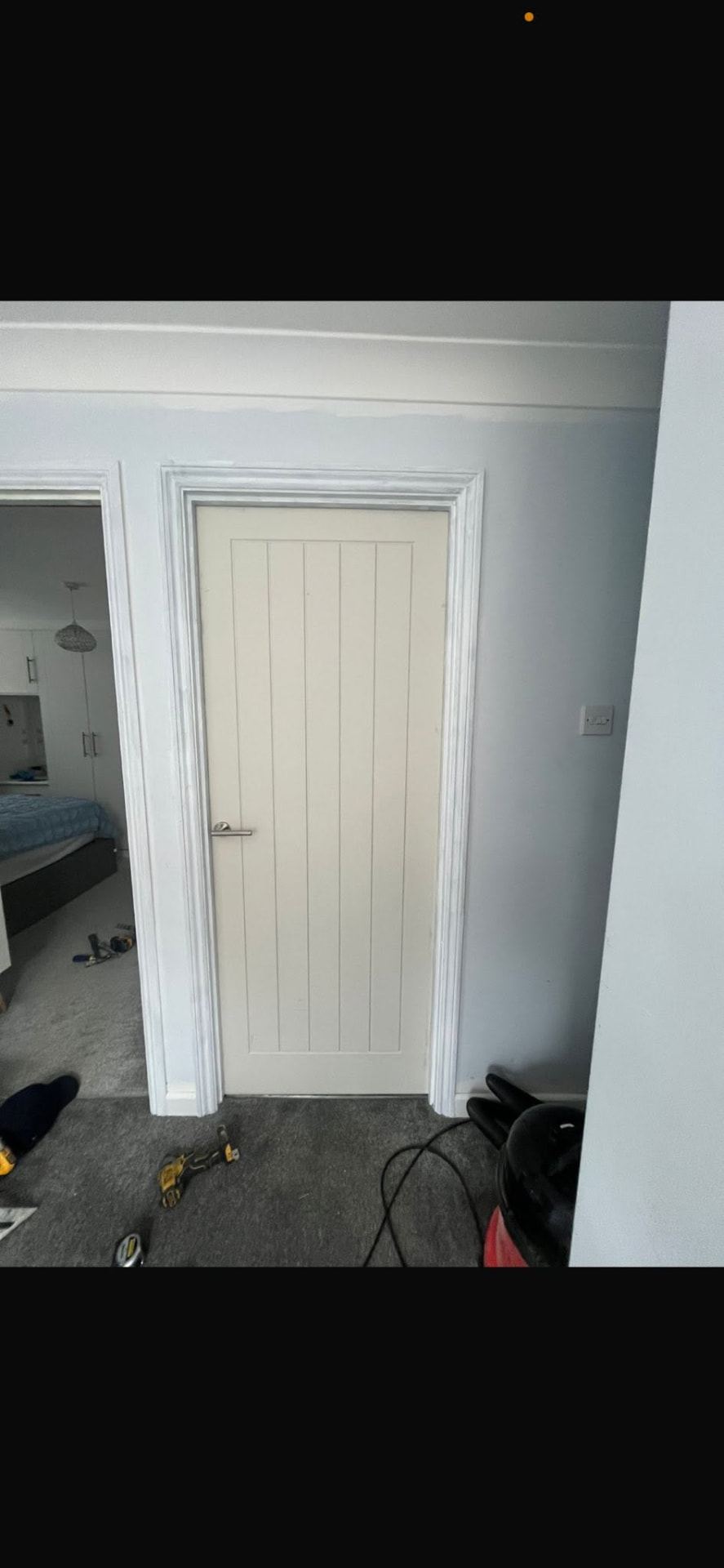 Completed white cottage door hung in the bedroom doorway