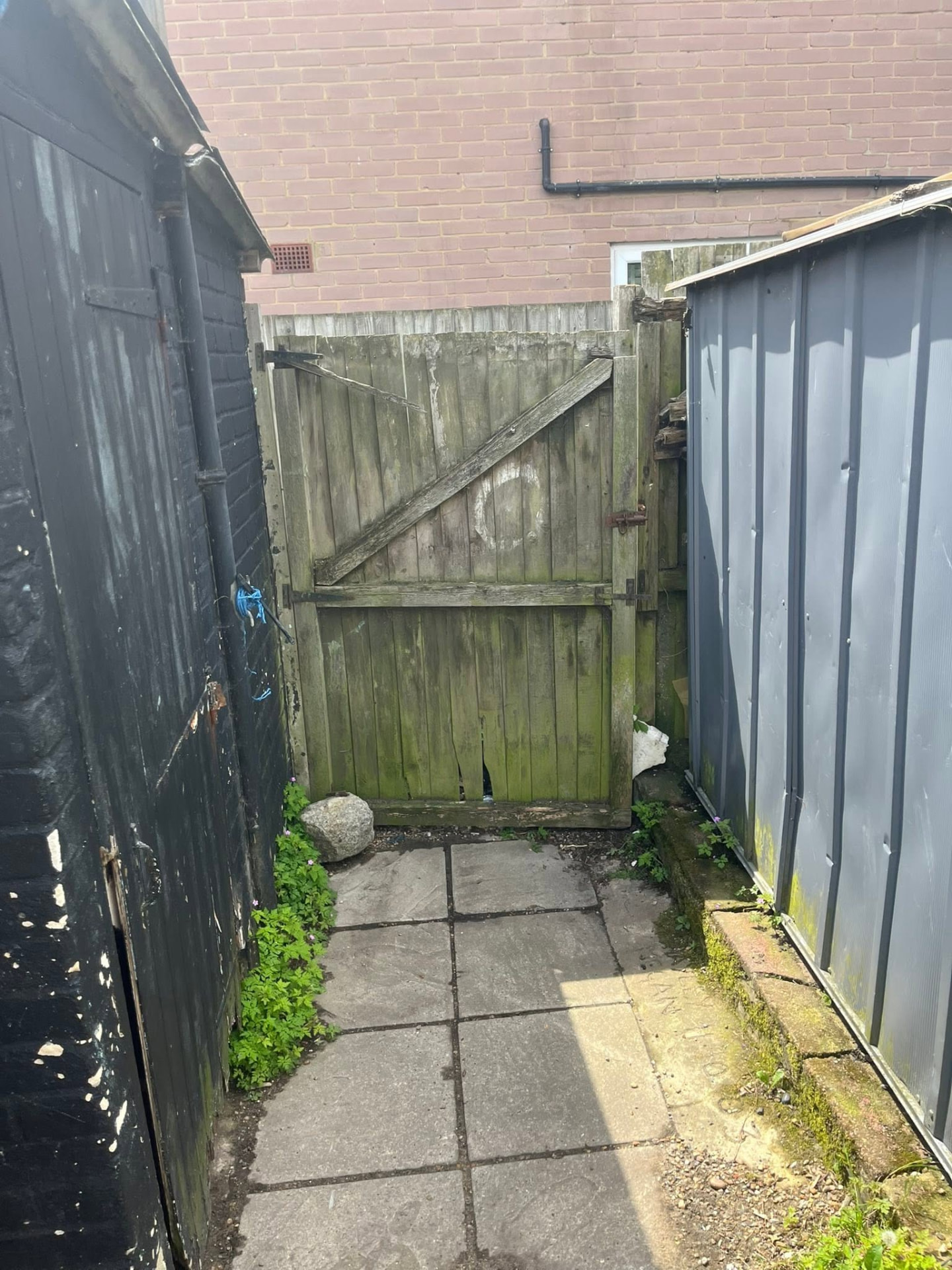 Old mossy side gate and worn fencing before the transformation