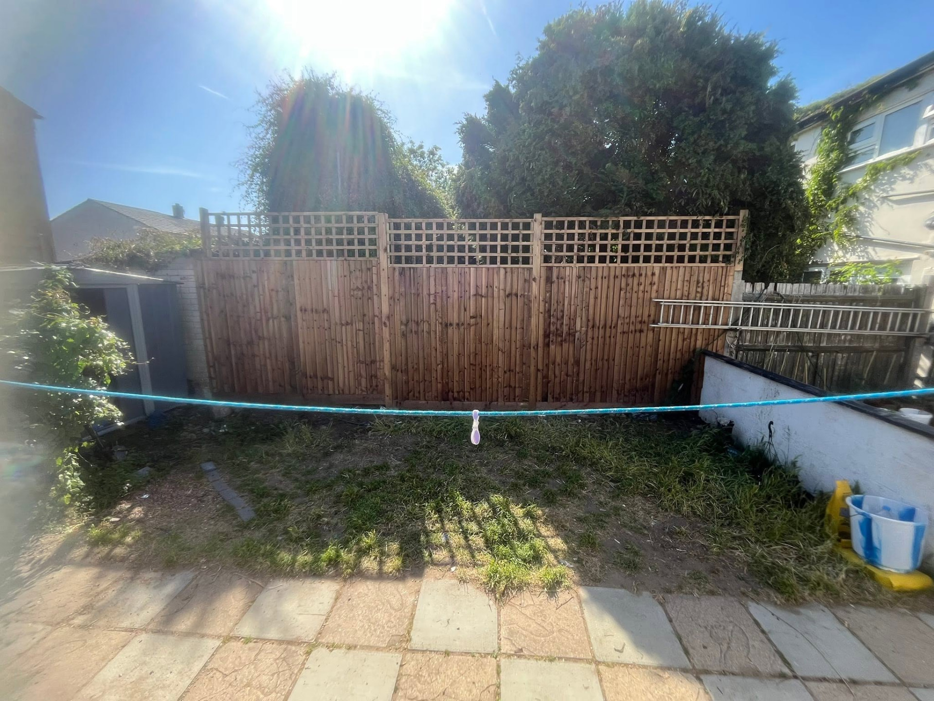 Newly installed close-board timber garden fence with decorative lattice trellis top