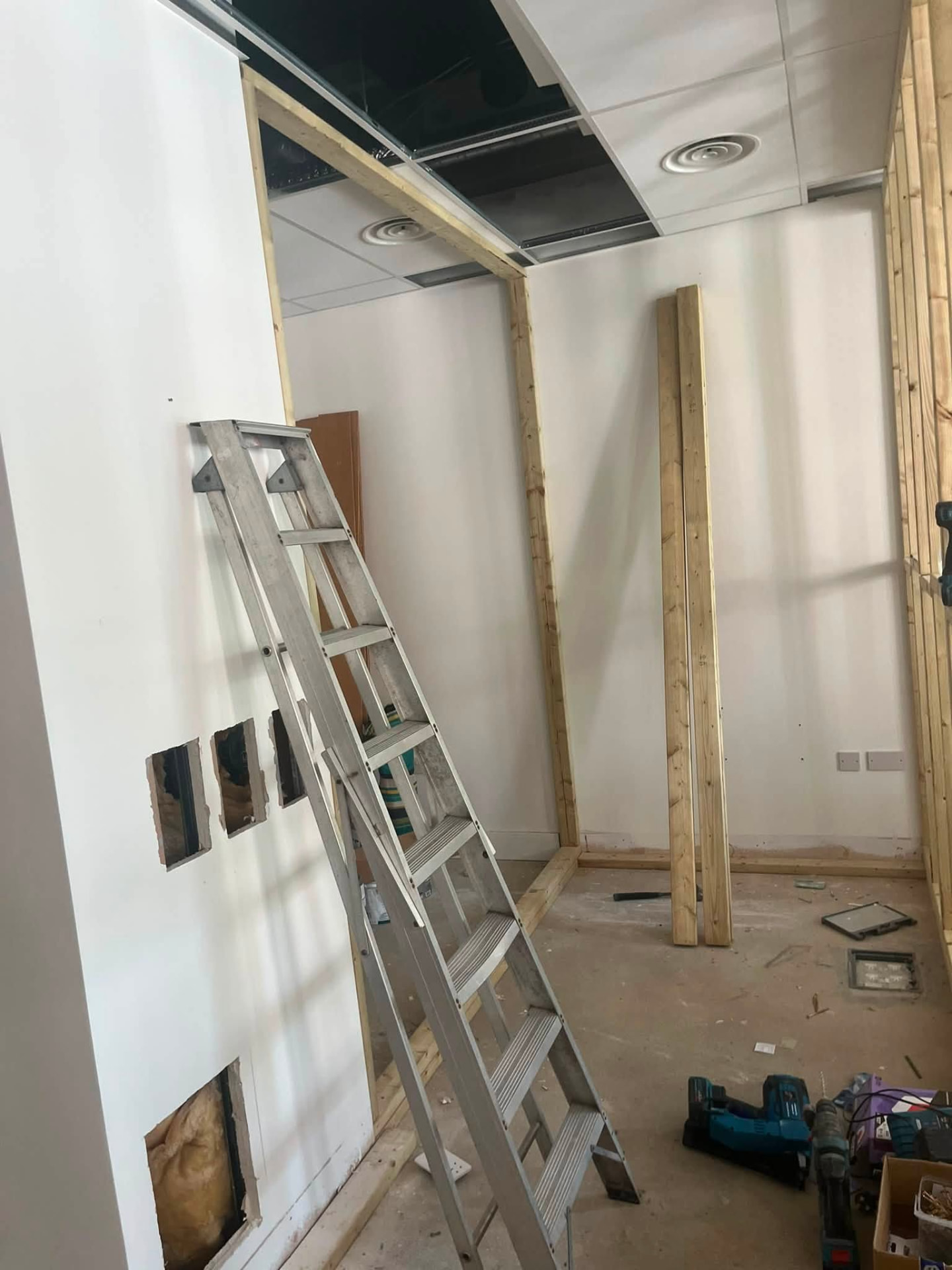 Timber framing built up to the ceiling grid with boarding started