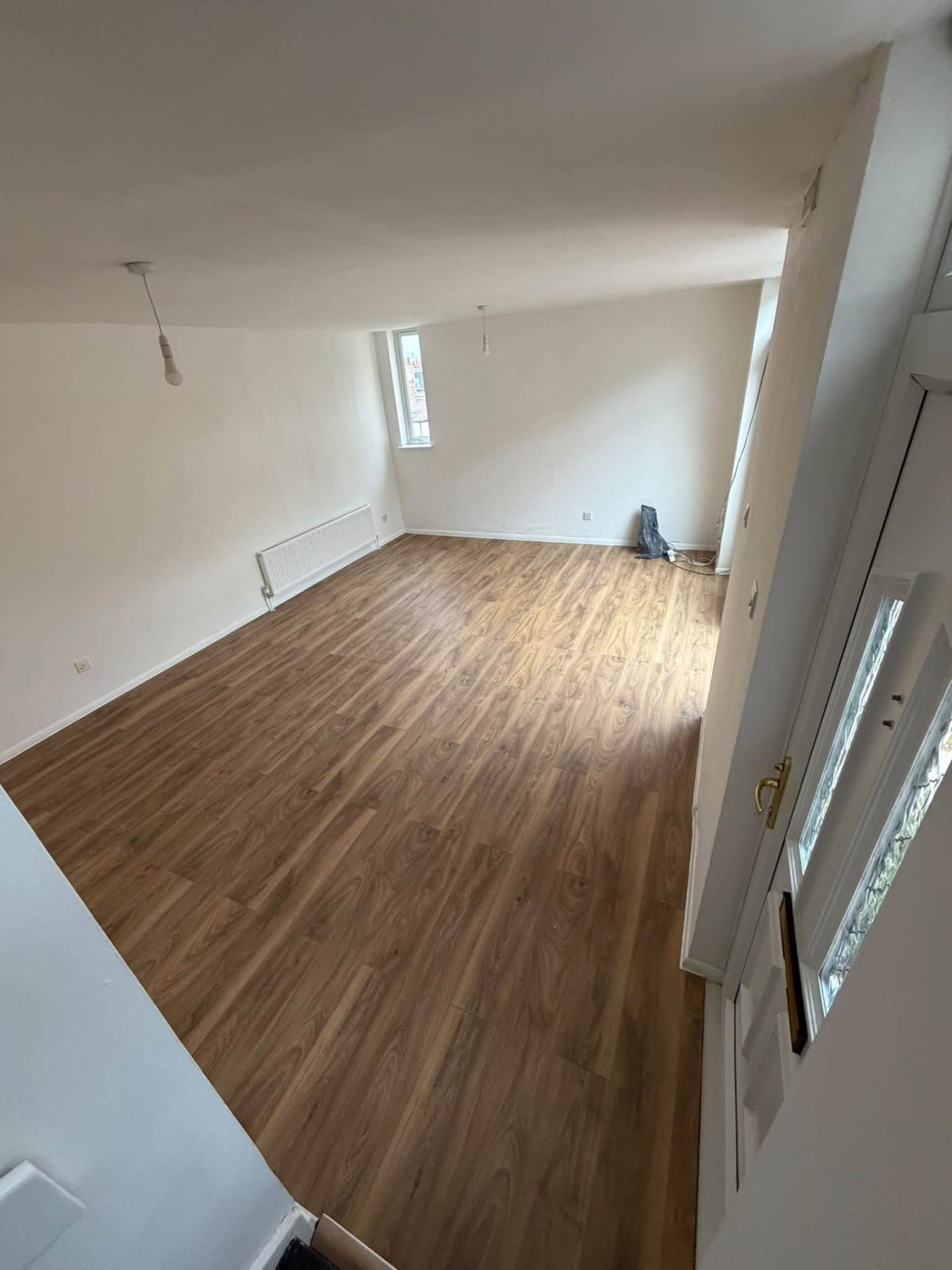 Completed living room with fresh flooring, painted walls and pendant light fittings