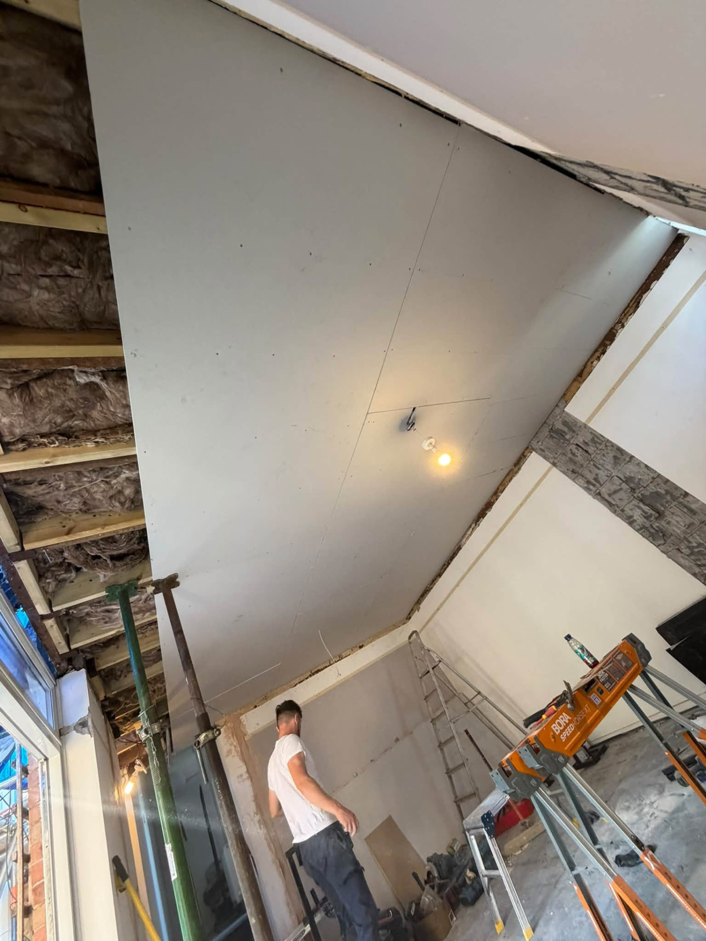 New plasterboard ceiling being installed in the refurbished room