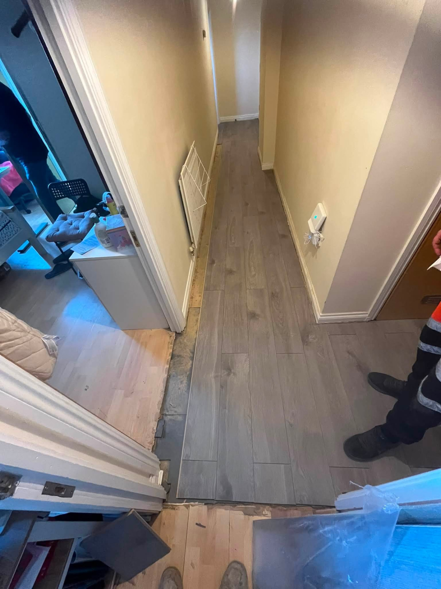 Hallway flooring nearing completion with new grey oak laminate laid to the doorways
