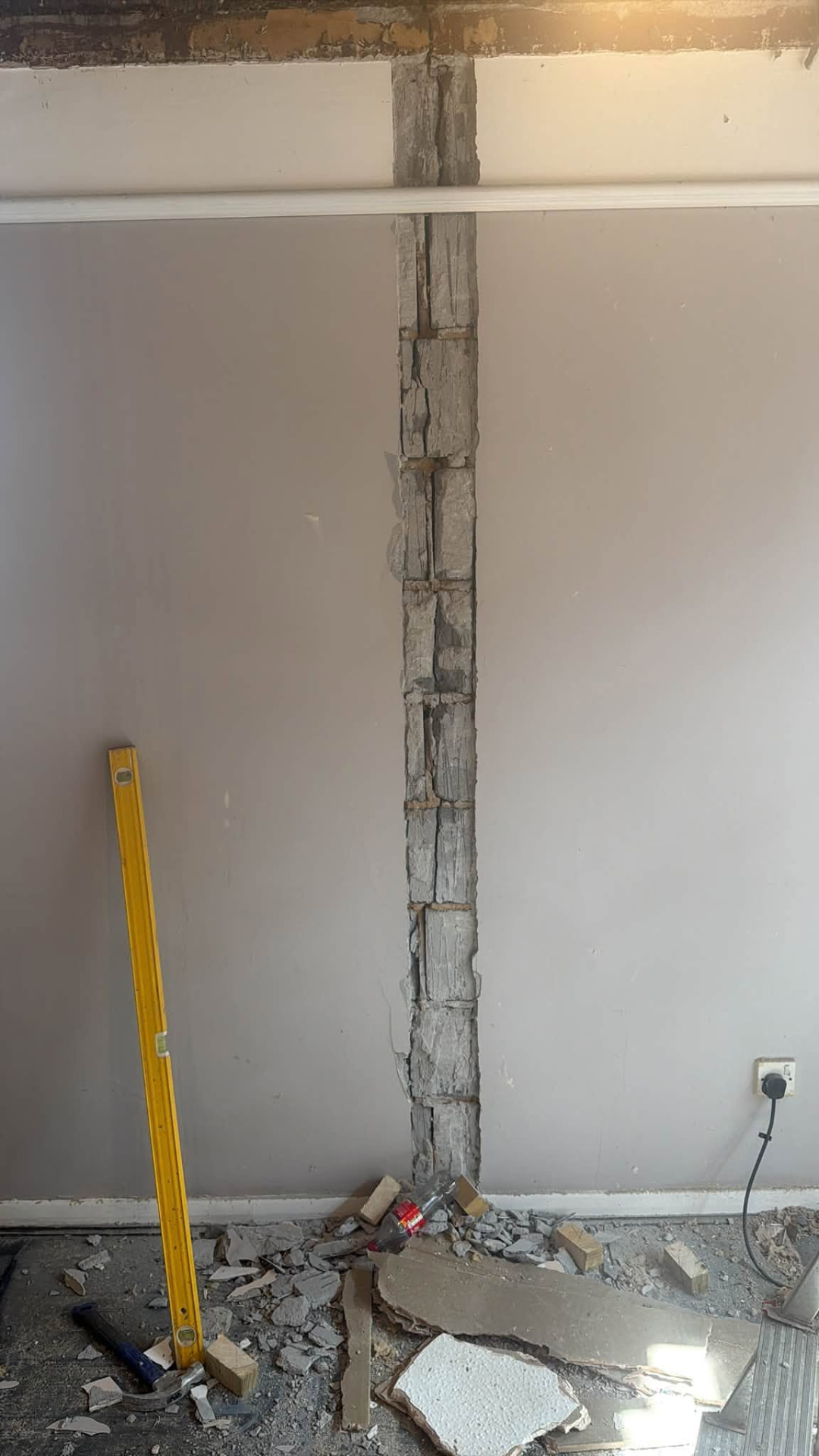 Plaster cut back to expose the damaged blockwork behind the wall