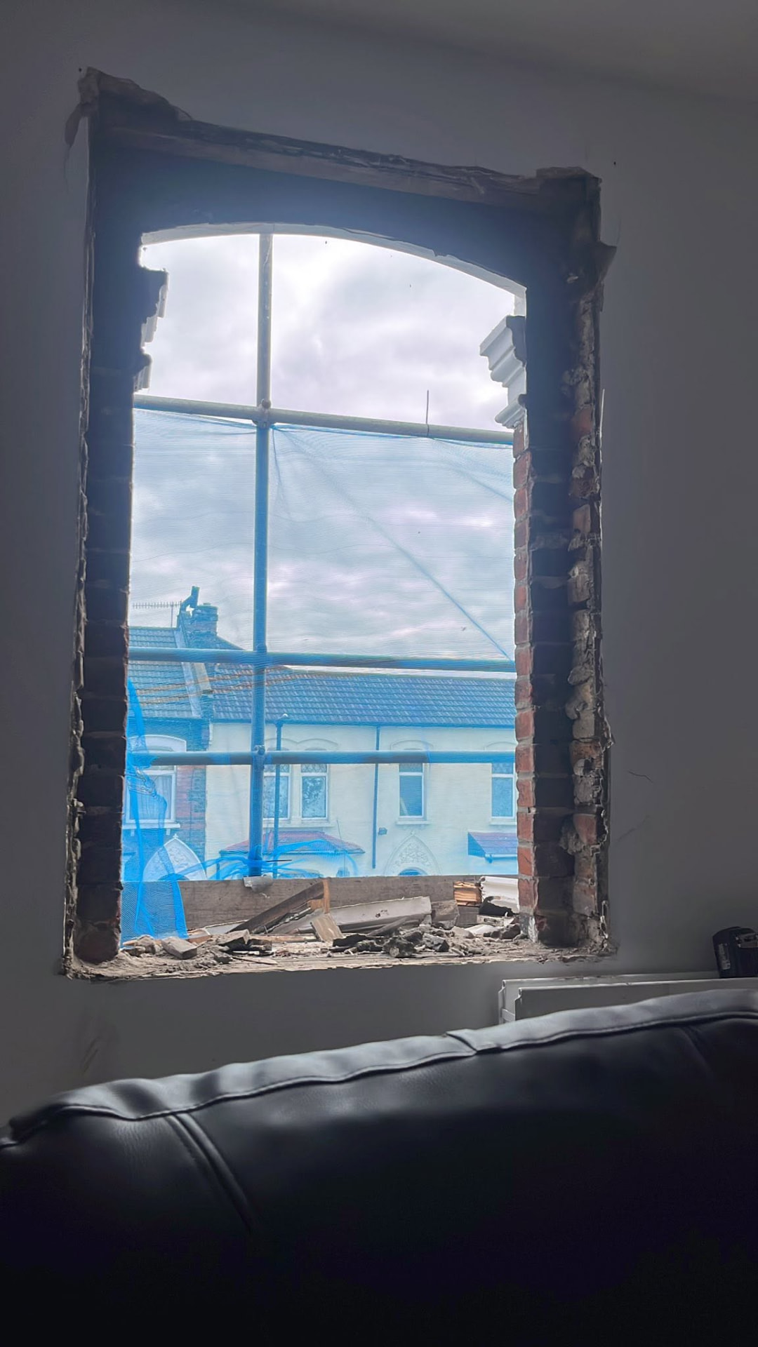 Old single-glazed sash window removed leaving an open brick opening
