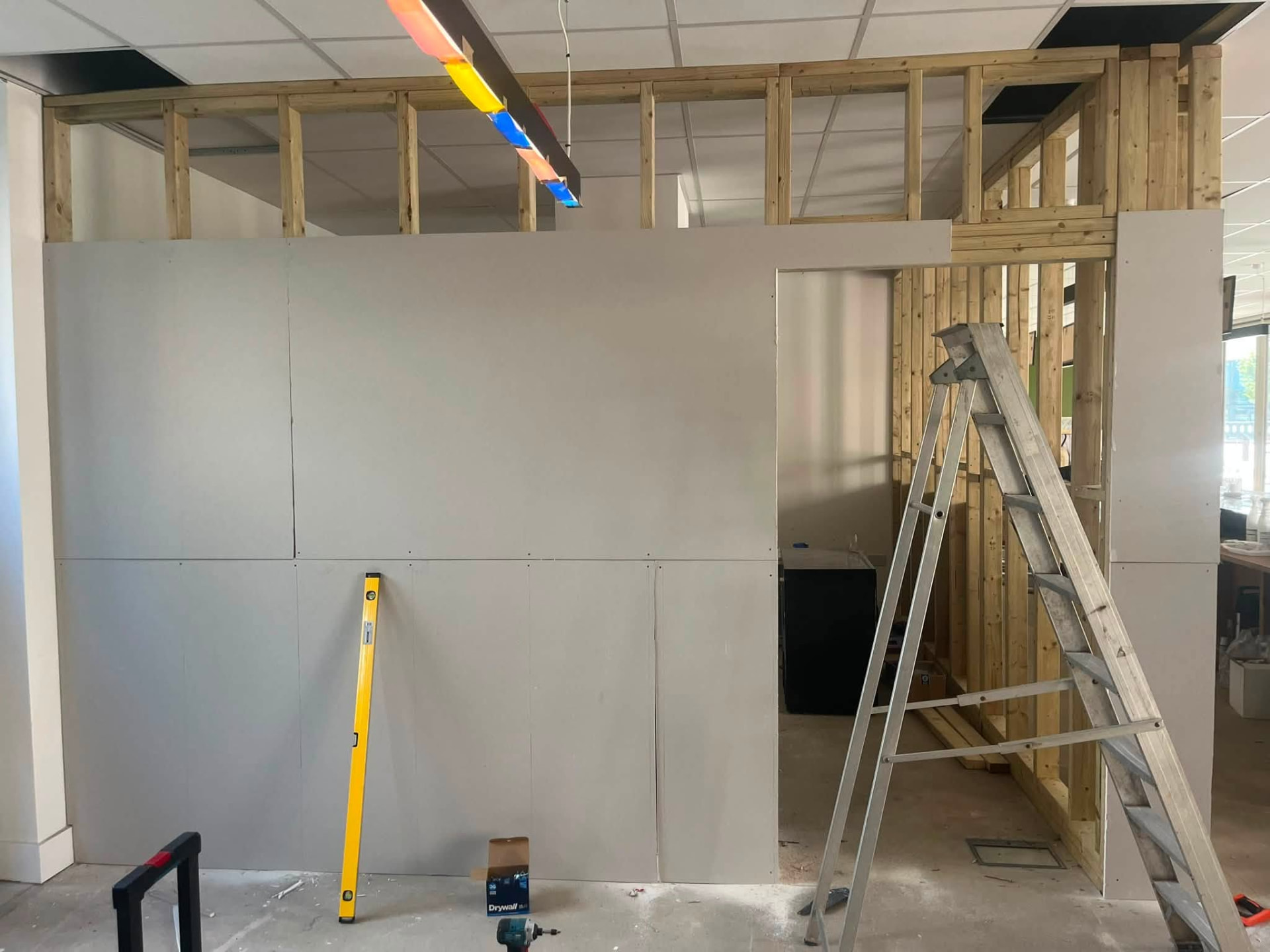 Plasterboard cladding being fixed to the timber stud partitions