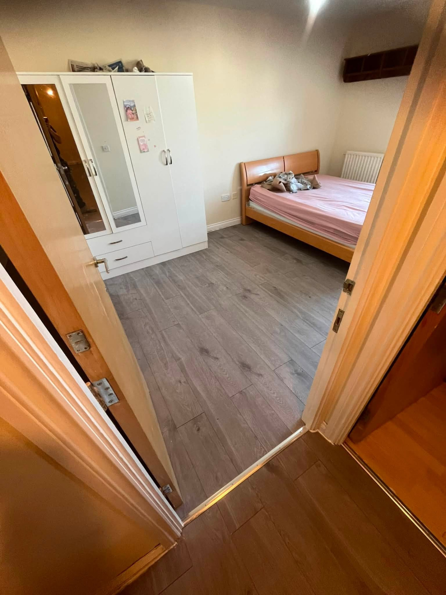 Completed bedroom with new grey oak laminate flooring laid throughout