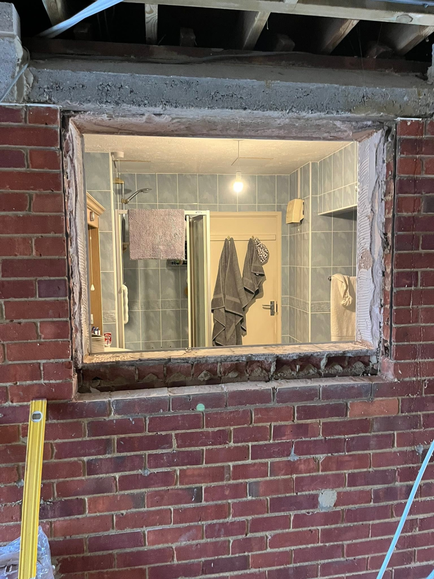 Old window opening stripped out of the brickwork with a concrete lintel above