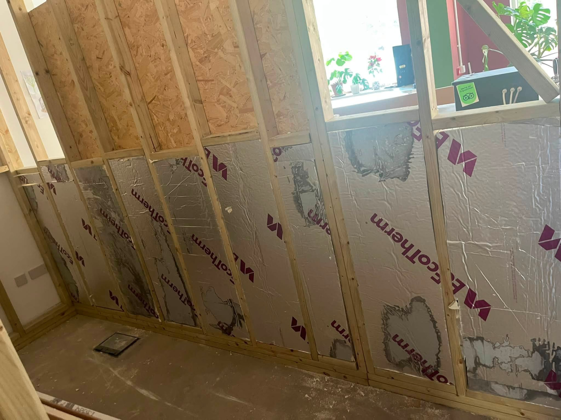 Insulation boards fitted between timber studs on the external wall