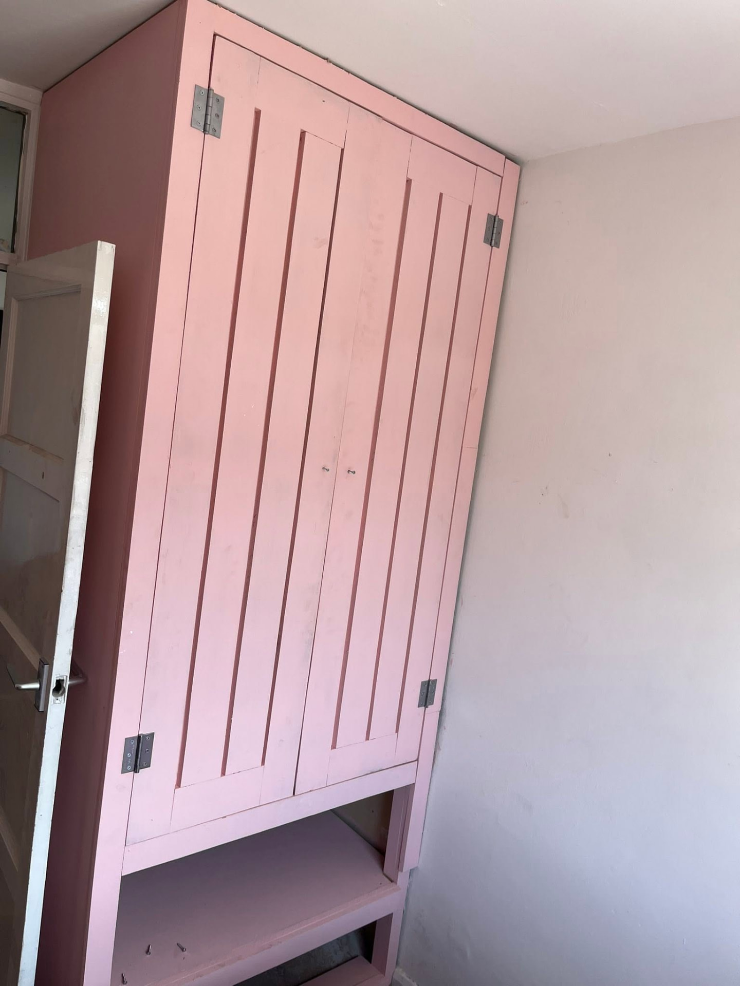 Completed made-to-measure MDF panel wardrobe painted in soft pink with open shelving below