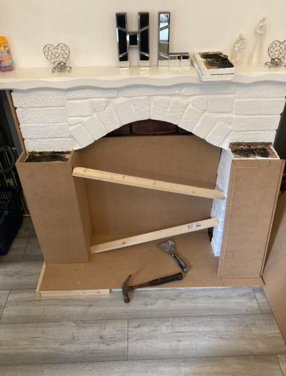 Original brick fireplace arch exposed behind the new MDF framework