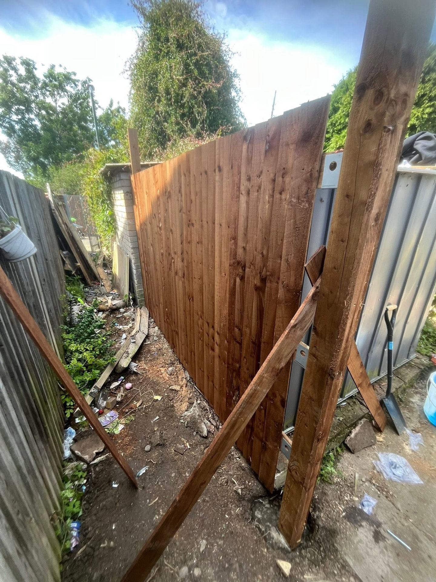 New fence panels fitted along the side alley with posts braced