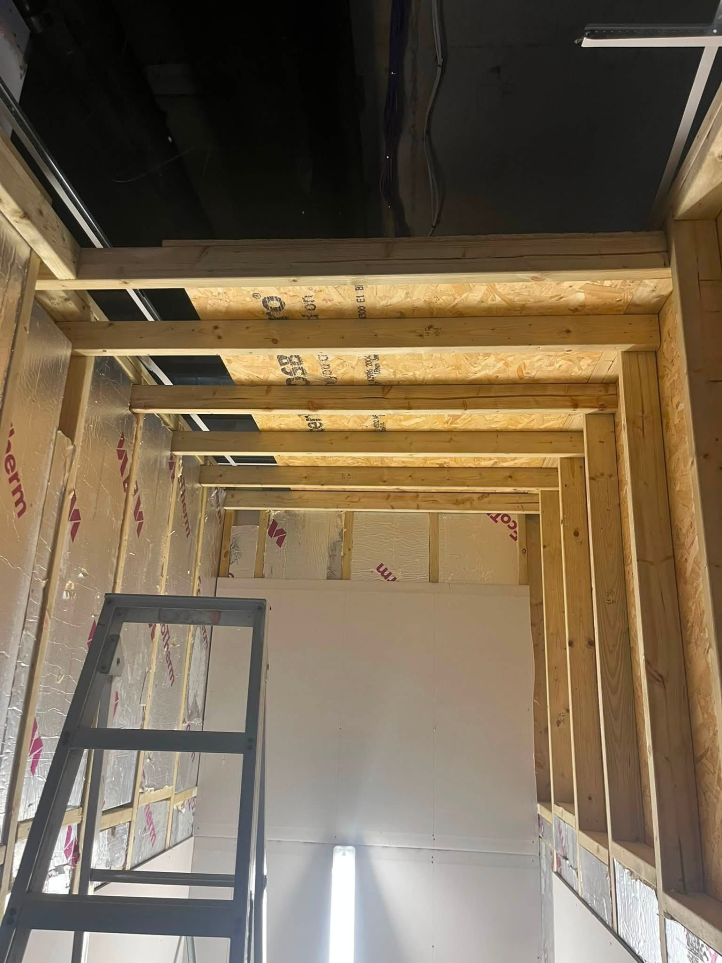 Timber ceiling joists and insulated stud walls formed in the new corridor