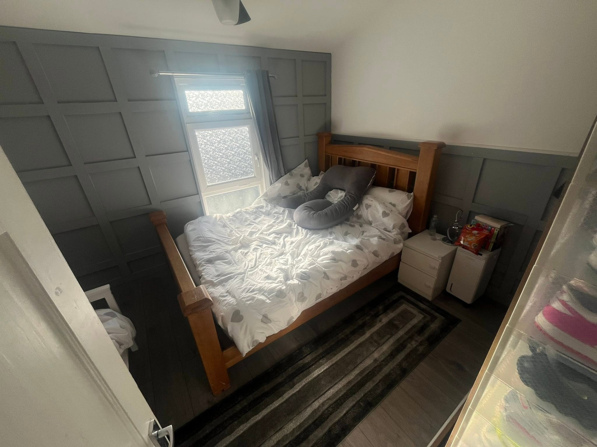 Completed bedroom showing full-wall grey panelling and new flooring