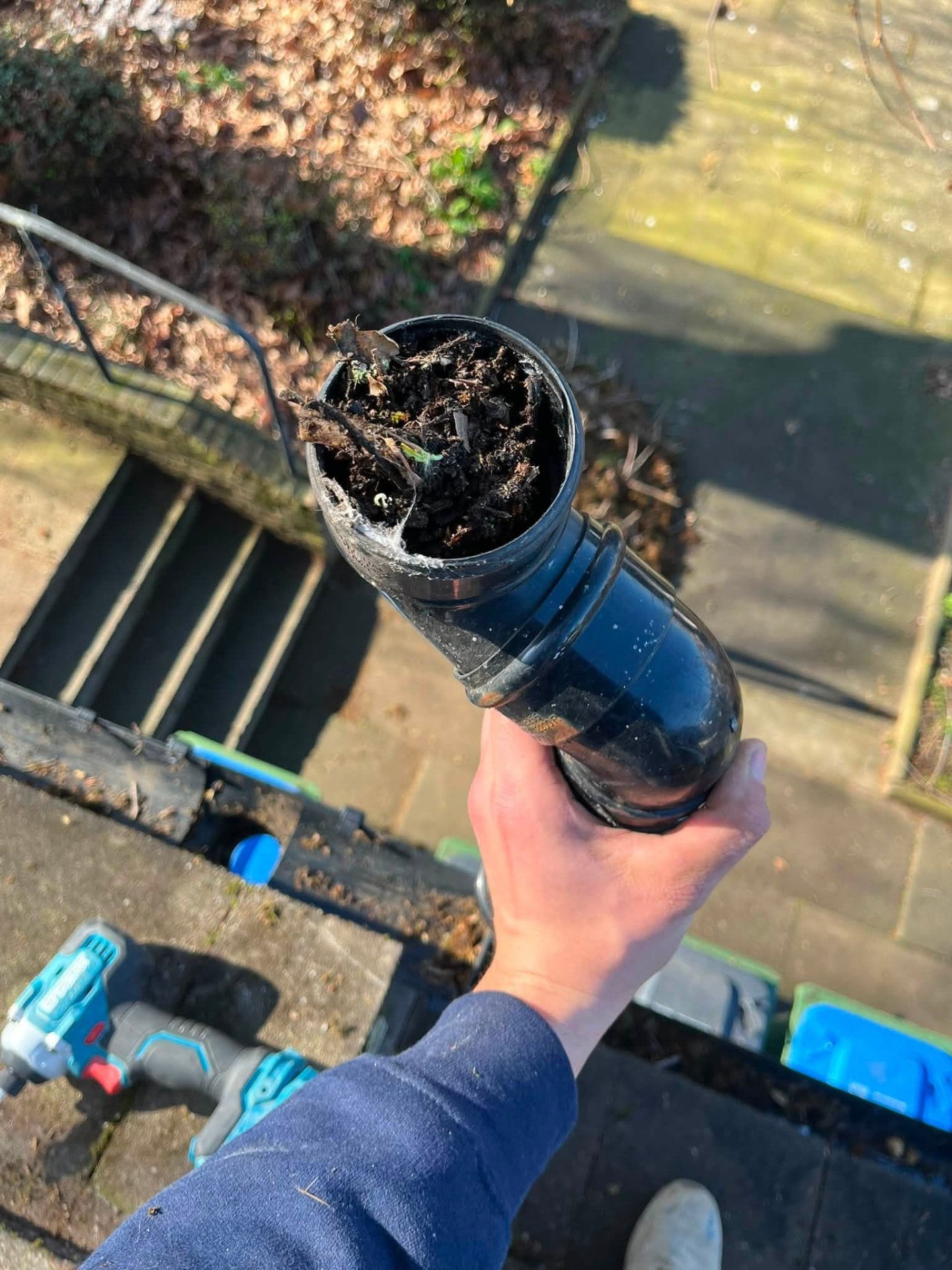 Downpipe section removed showing heavy moss and debris blockage