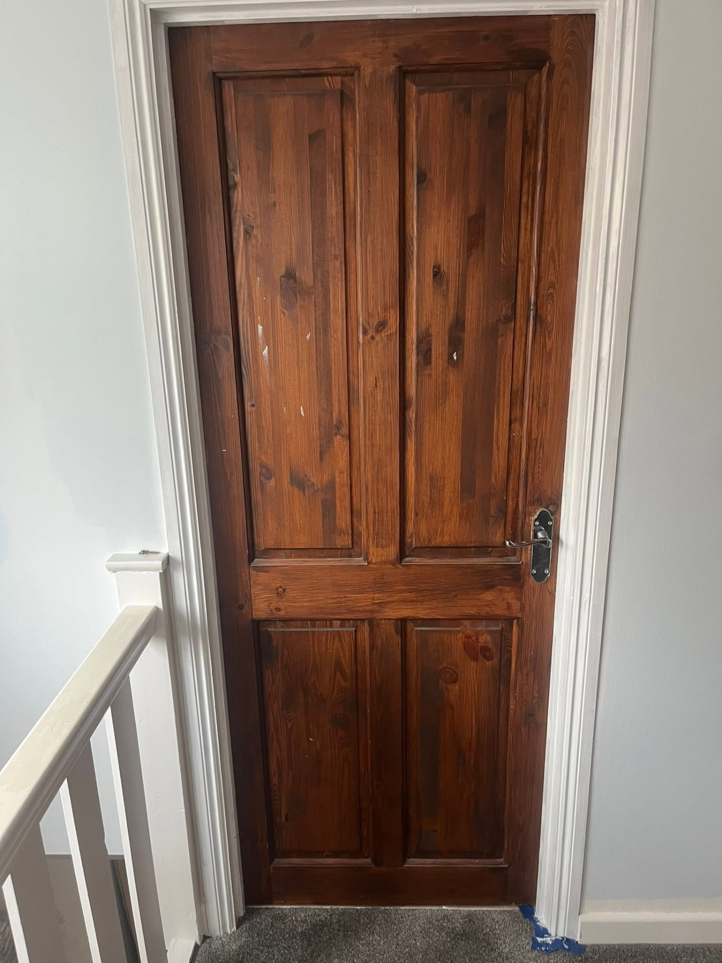 Old stained timber door at the top of the stairs